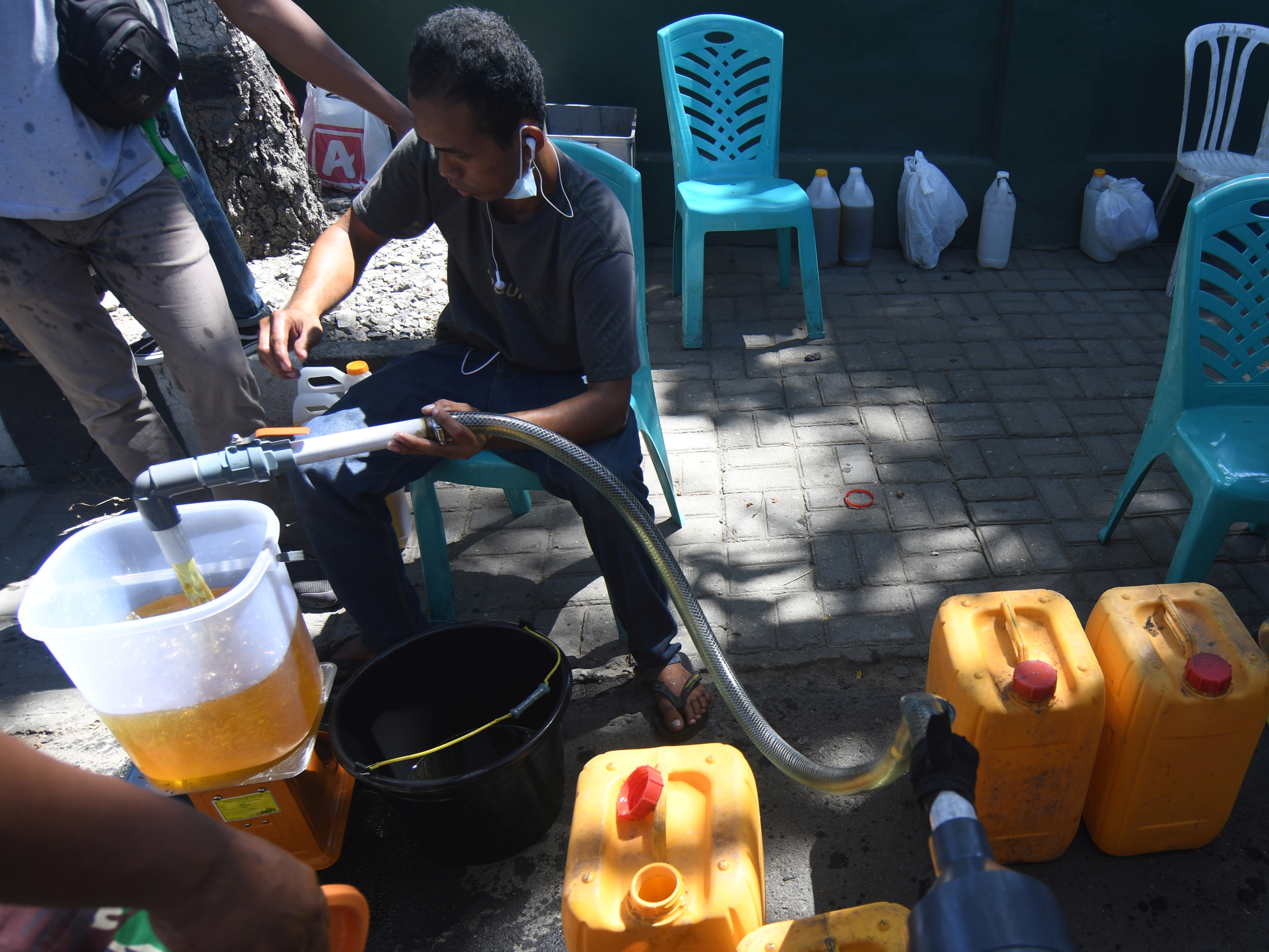 Petugas mengisi minyak goreng curah ke jerikan warga saat proses pendistribusian pada gelaran pasar murah di Palu, Sulteng.