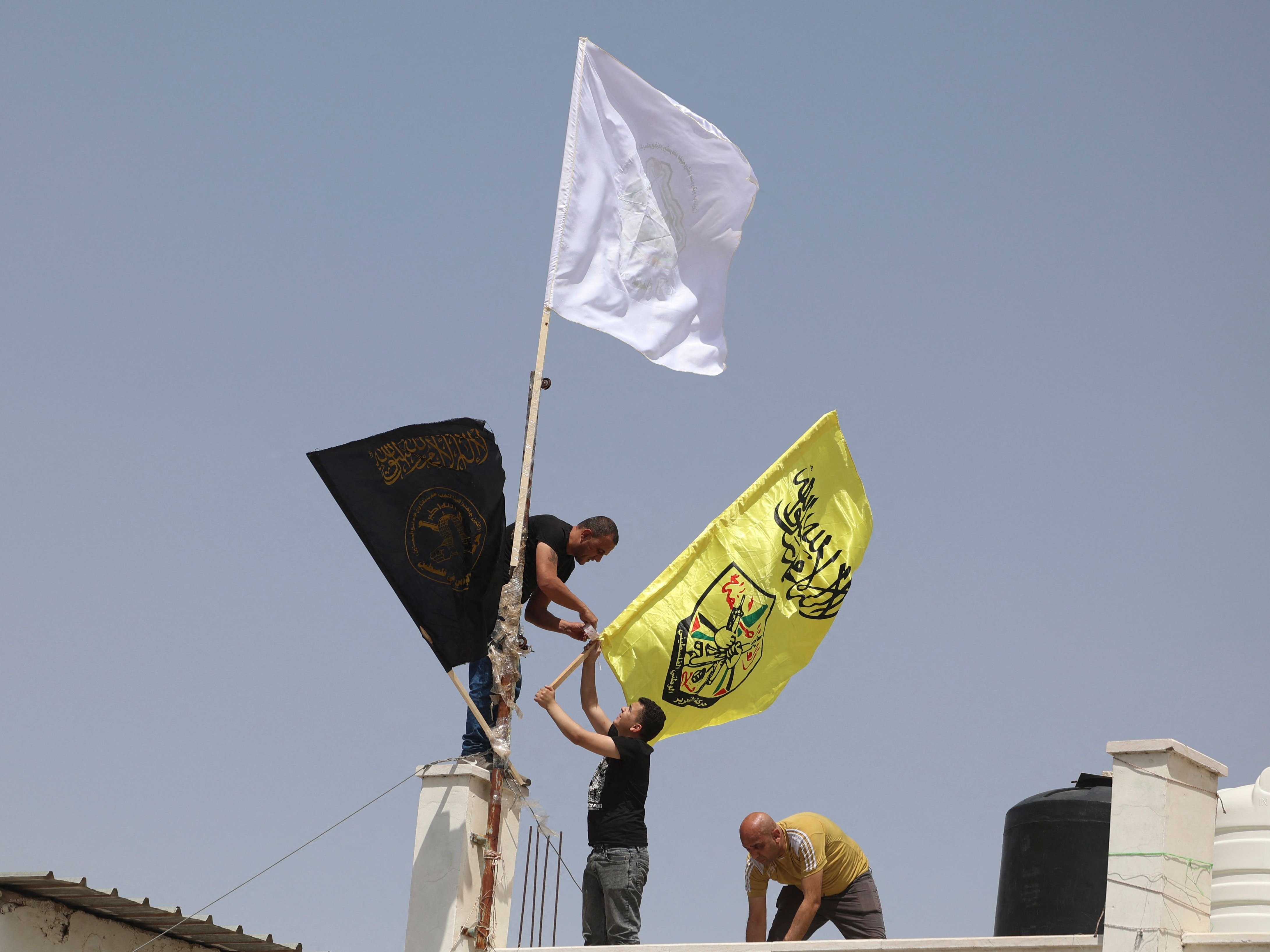Militan mengibarkan bendera setelah pemimpin militan Palestina terkemuka Daoud al-Zubaidi meninggal karena luka yang dideritanya.