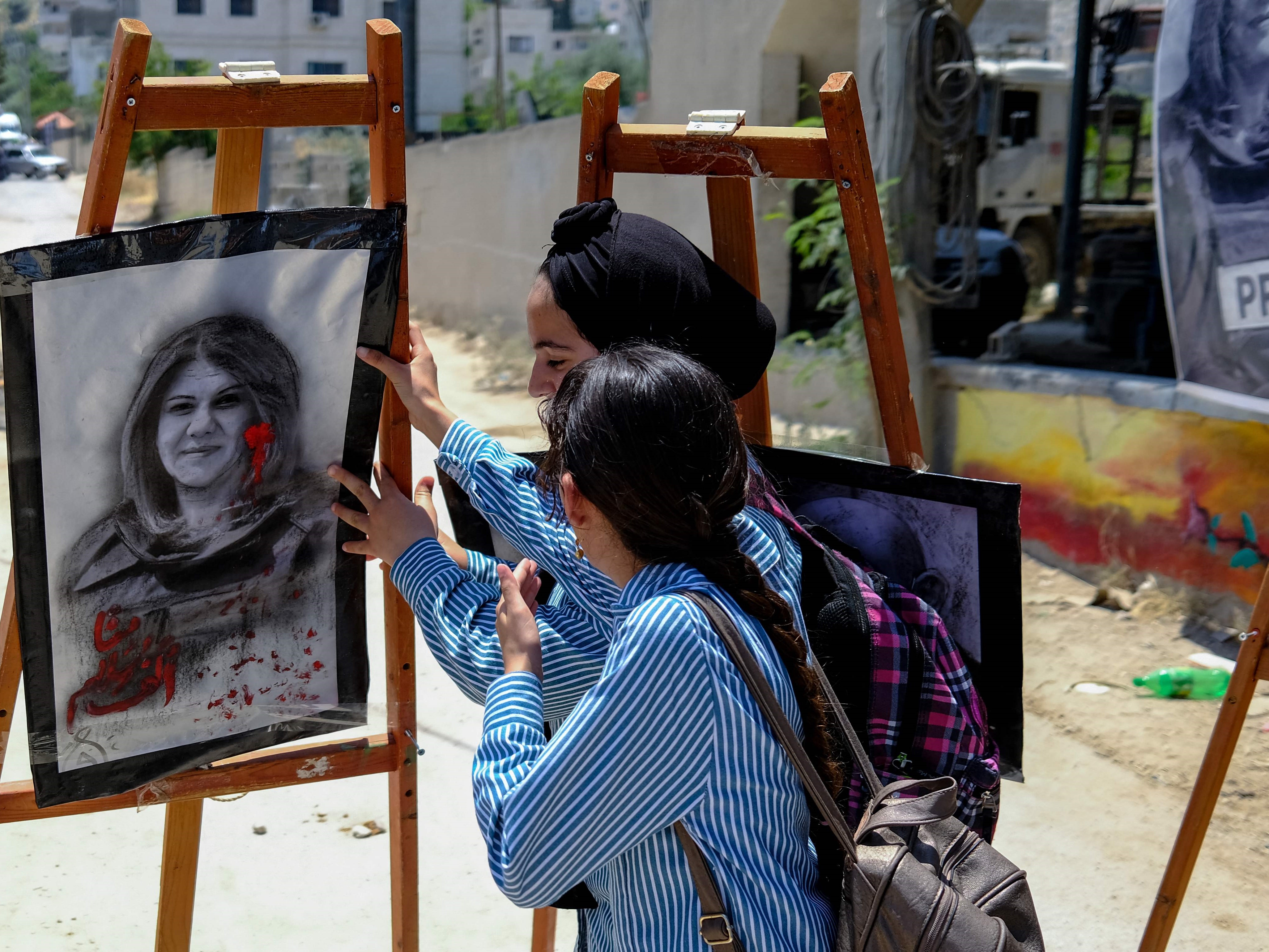 Dua gadis menghadiri pameran seni untuk menghormati mendiang jurnalis Al-Jazeera Palestina Shireen Abu Akleh di kota Jenin di Tepi Barat.