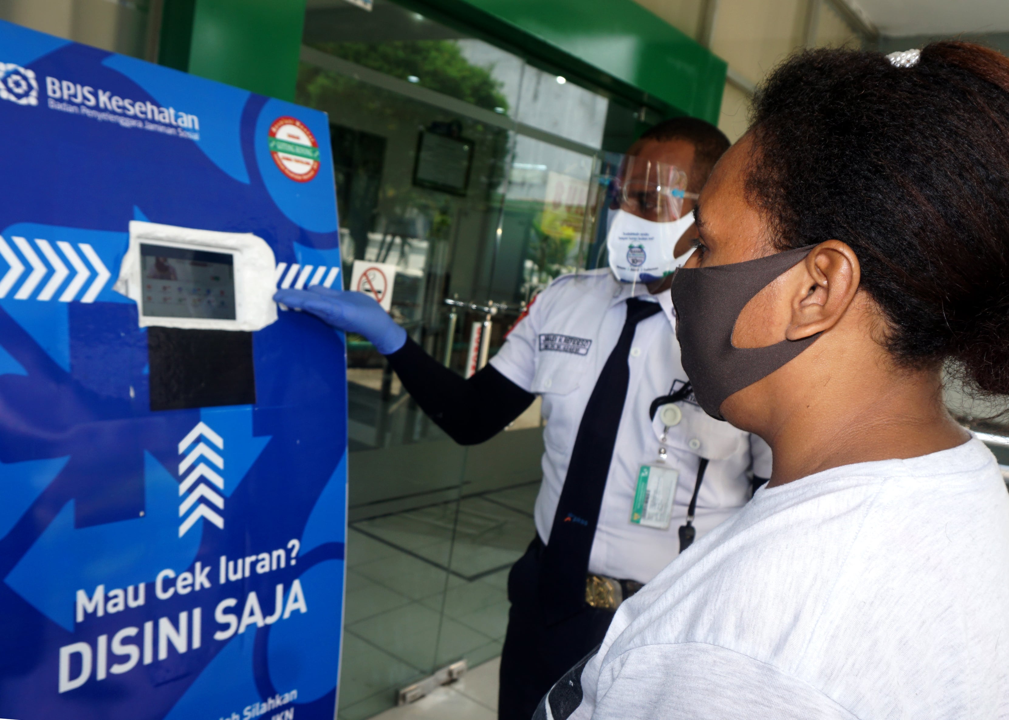 Seorang warga mengecek iuran di info box Kantor BPJS Kesehatan, Kota Jayapura, Papua,