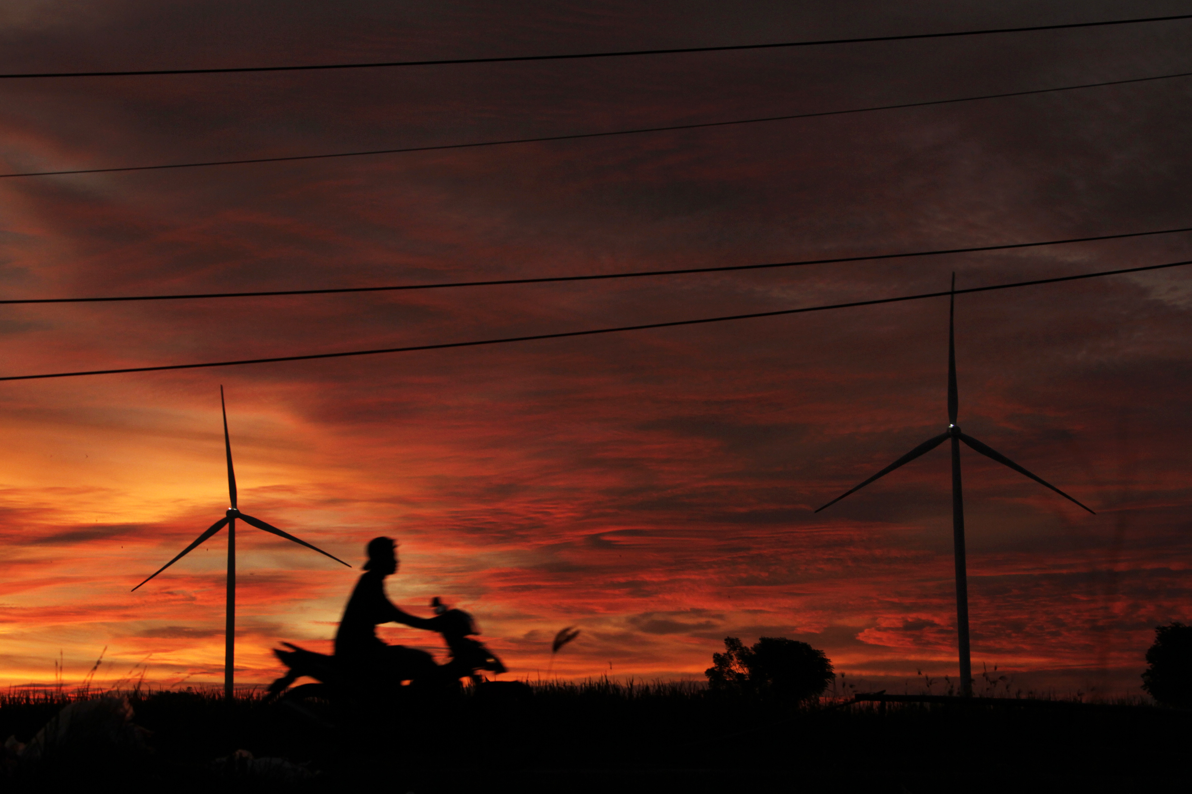 Pengendara melintas di area Pembangkit Listrik Tenaga Bayu (PLTB) Tolo di Kabupaten Jeneponto, Sulawesi Selatan