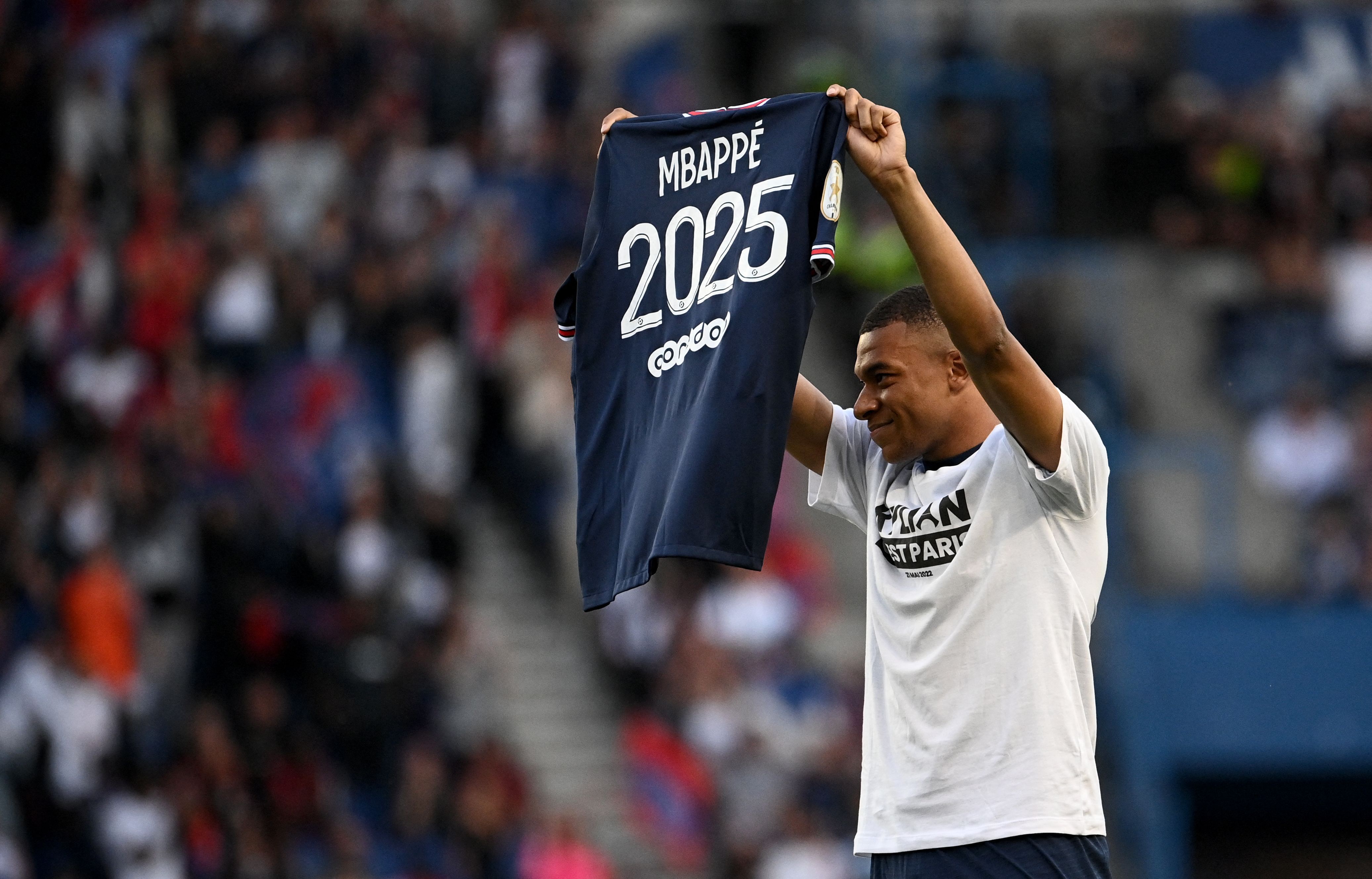 Penyerang PSG Kylian Mbappe berpose dengan jersey yang menampilkan angka 2025 setelah memperpanjang kontrak dengan klub Ligue 1 itu.