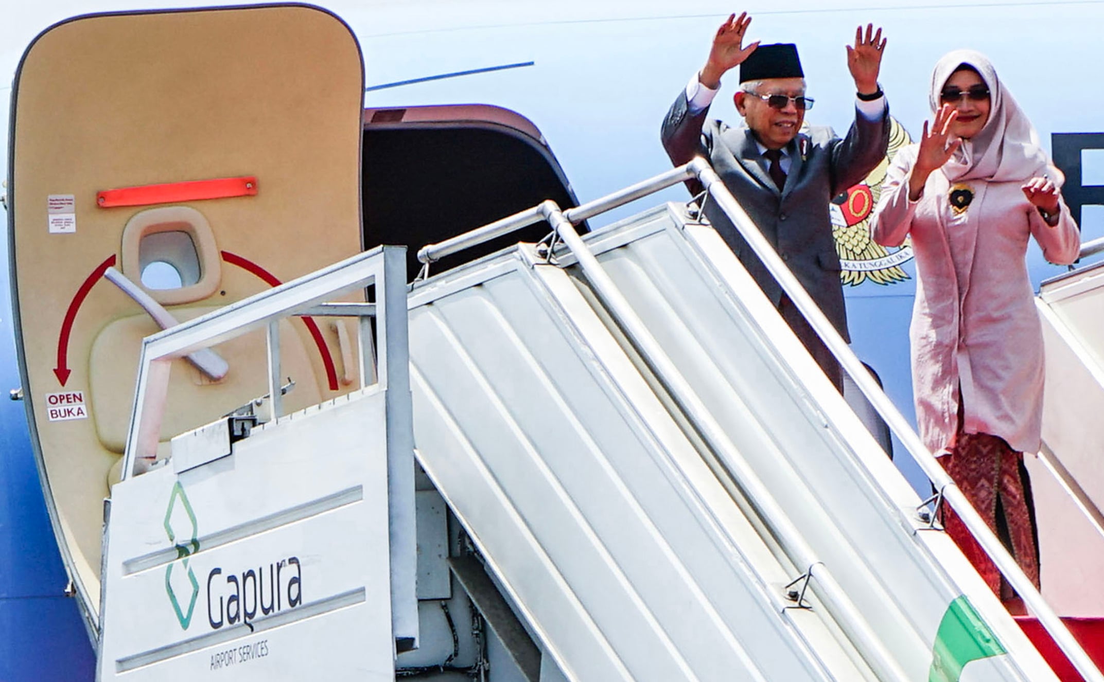 Wakil Presiden Ma'ruf Amin (kiri) didampingi istri Wuri Estu Handayani Ma'ruf Amin (kanan) melambaikan tangan sebelum masuk ke dalam Pesawat