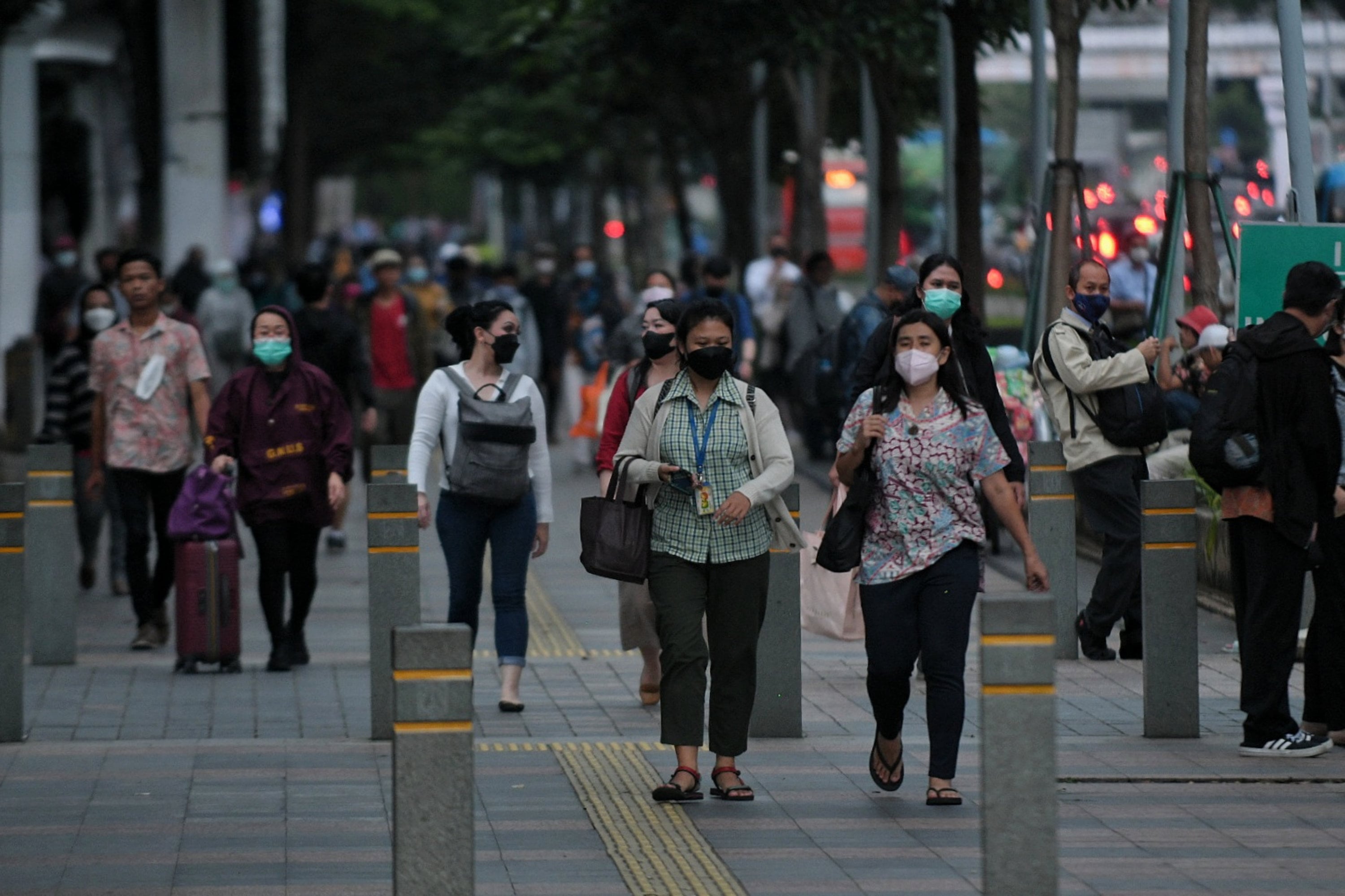 Pekerja berjalan di trotoar kawasan jalan Sudirman, Jakarta, Senin (9/5).