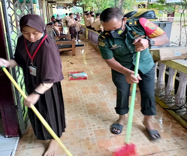 Foto prajurit TNI dari Koramil Telanaipura, Rabu (25/5) pagi, membantu membersihkan lingkungan sebuah sekolah di Kota Jambi