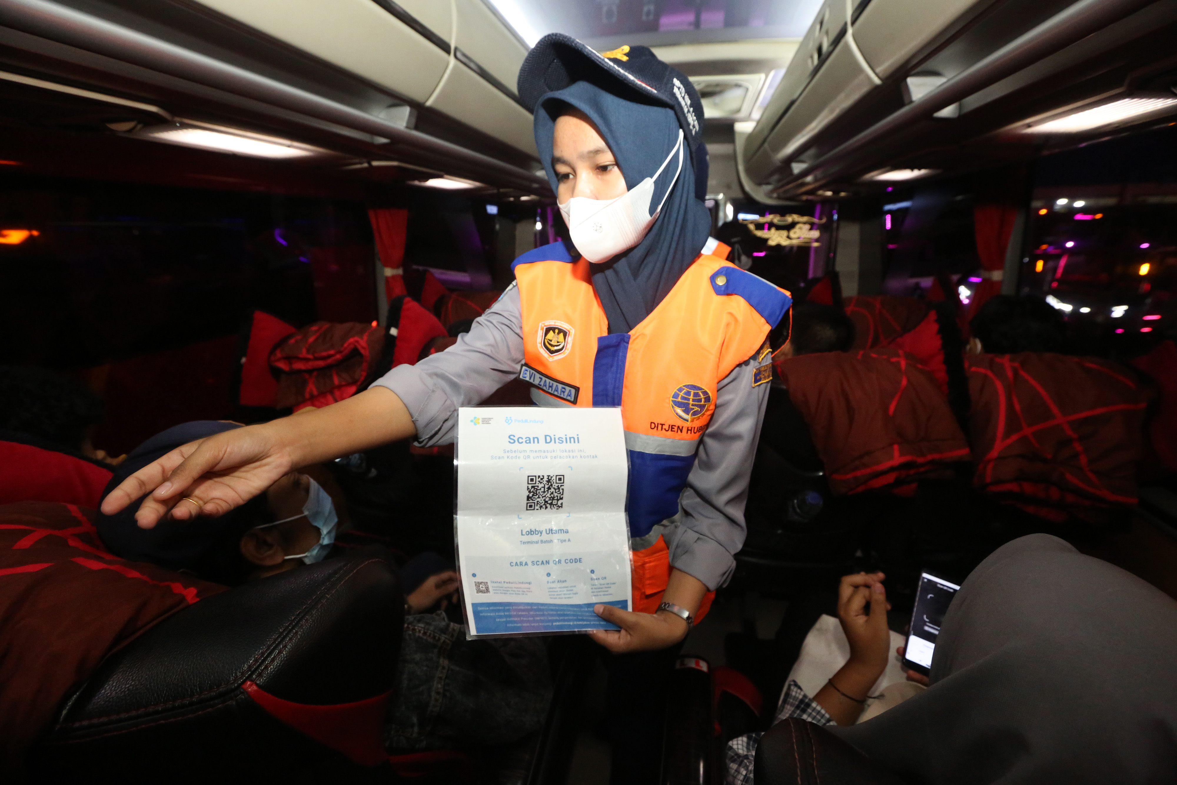 Petugas menghampiri penumpang bus AKAP untuk memindai QR Code aplikasi PeduliLindungi di terminal tipe A Batoh, Banda Aceh, Aceh.