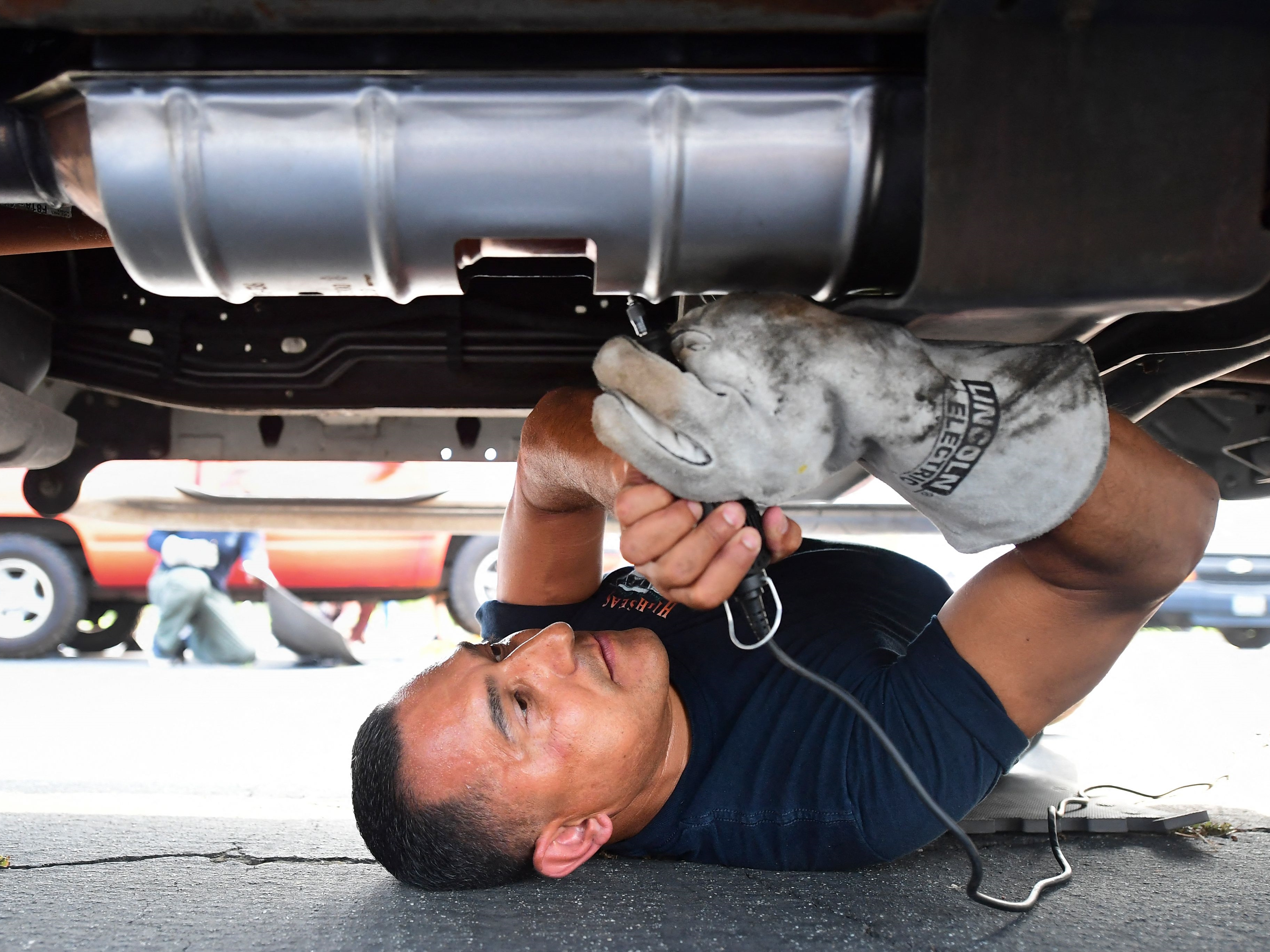 Deputi Jaime Moran dari Los Angeles Sheriffs Department mengukir catalytic converter kendaraan dengan nomor yang dapat dilacak.