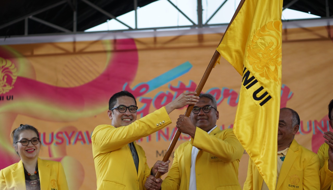 Ketua umum Iluni UI (kiri) memegang bendera Iluni