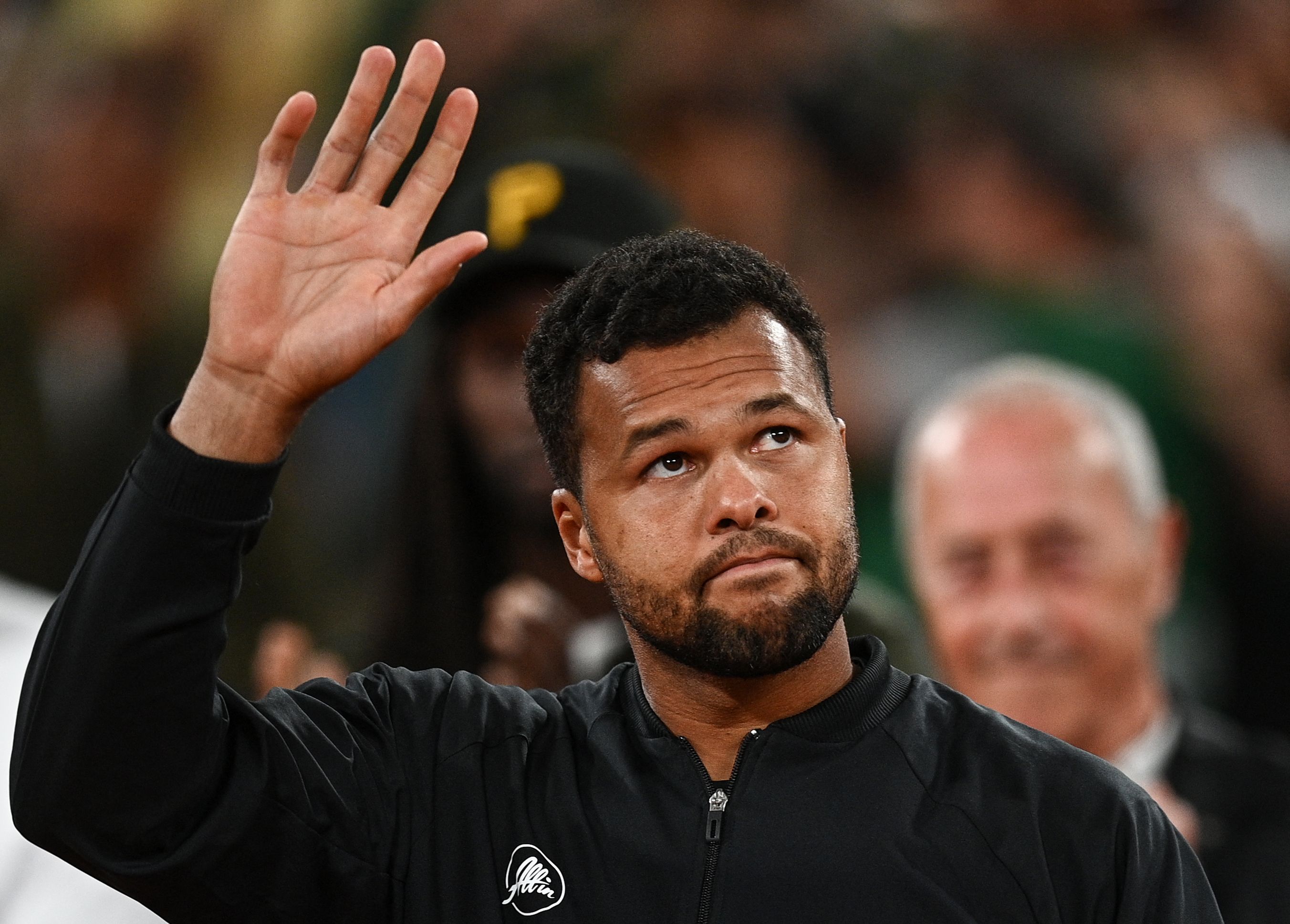 Petenis Prancis Jo-Wilfried Tsonga melambaikan tangan di upacara perpisahannya di Prancis Terbuka.
