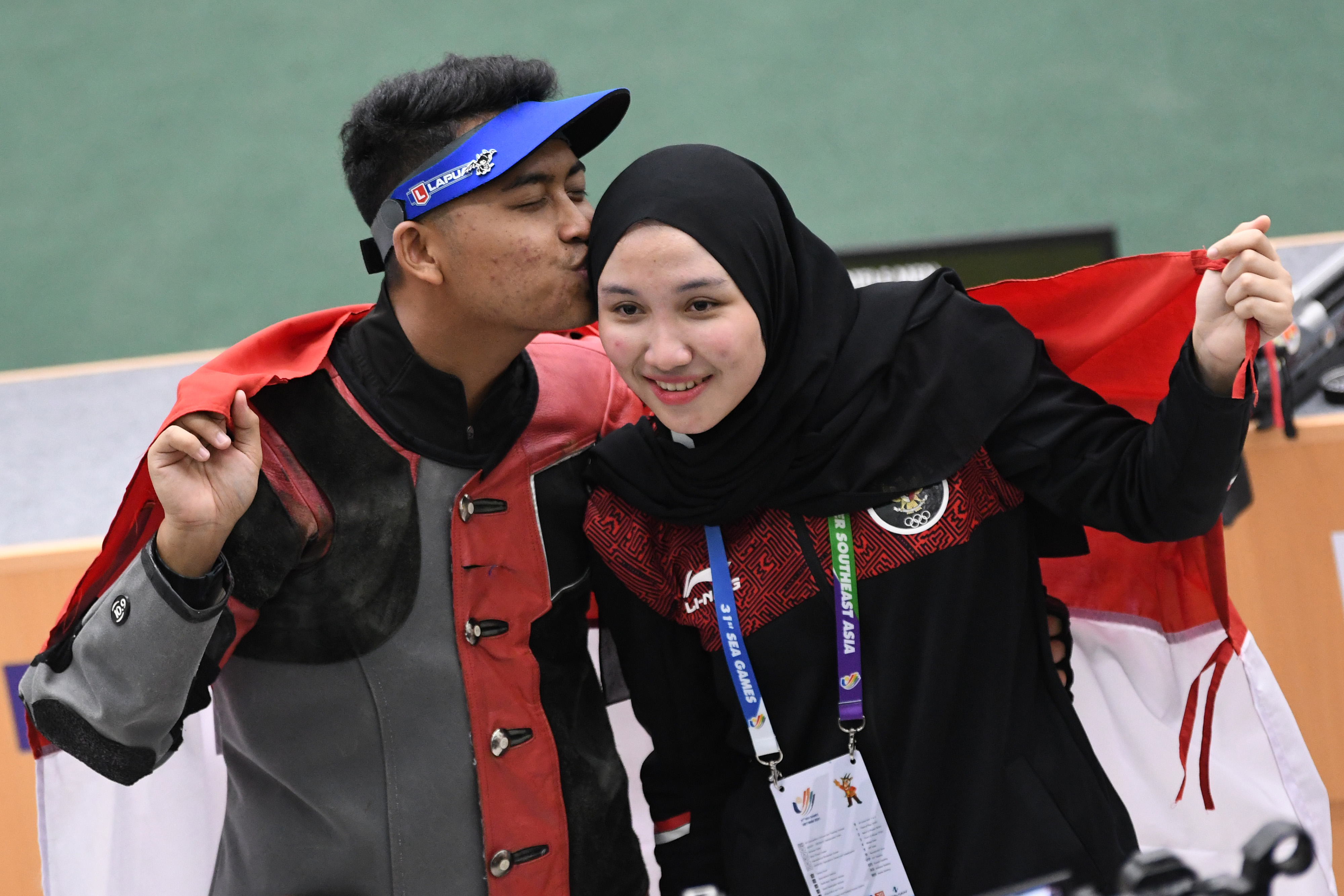 Penembak Fathur Gustafian (kiri) mencium kekasihnya Dewi Laila Mubarokah, usai memenangkan medali emas SEA Games 2021.