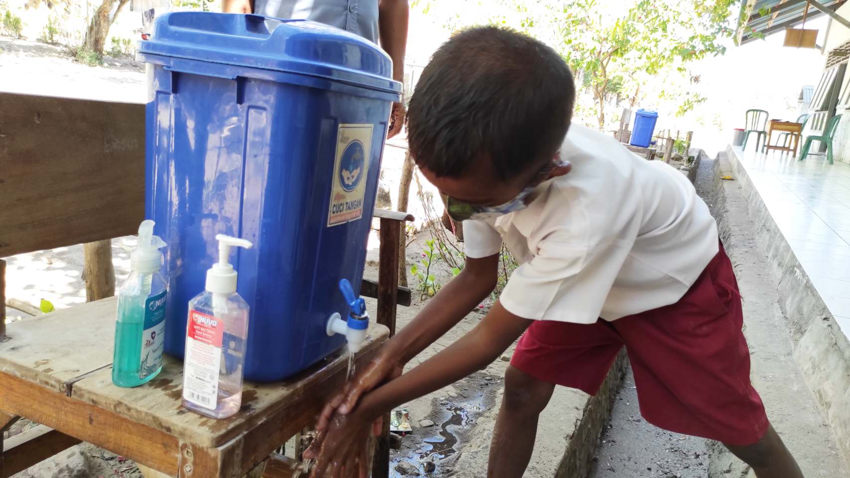 Seoramg siswa SD mencuci tangan menggunakan sabun.