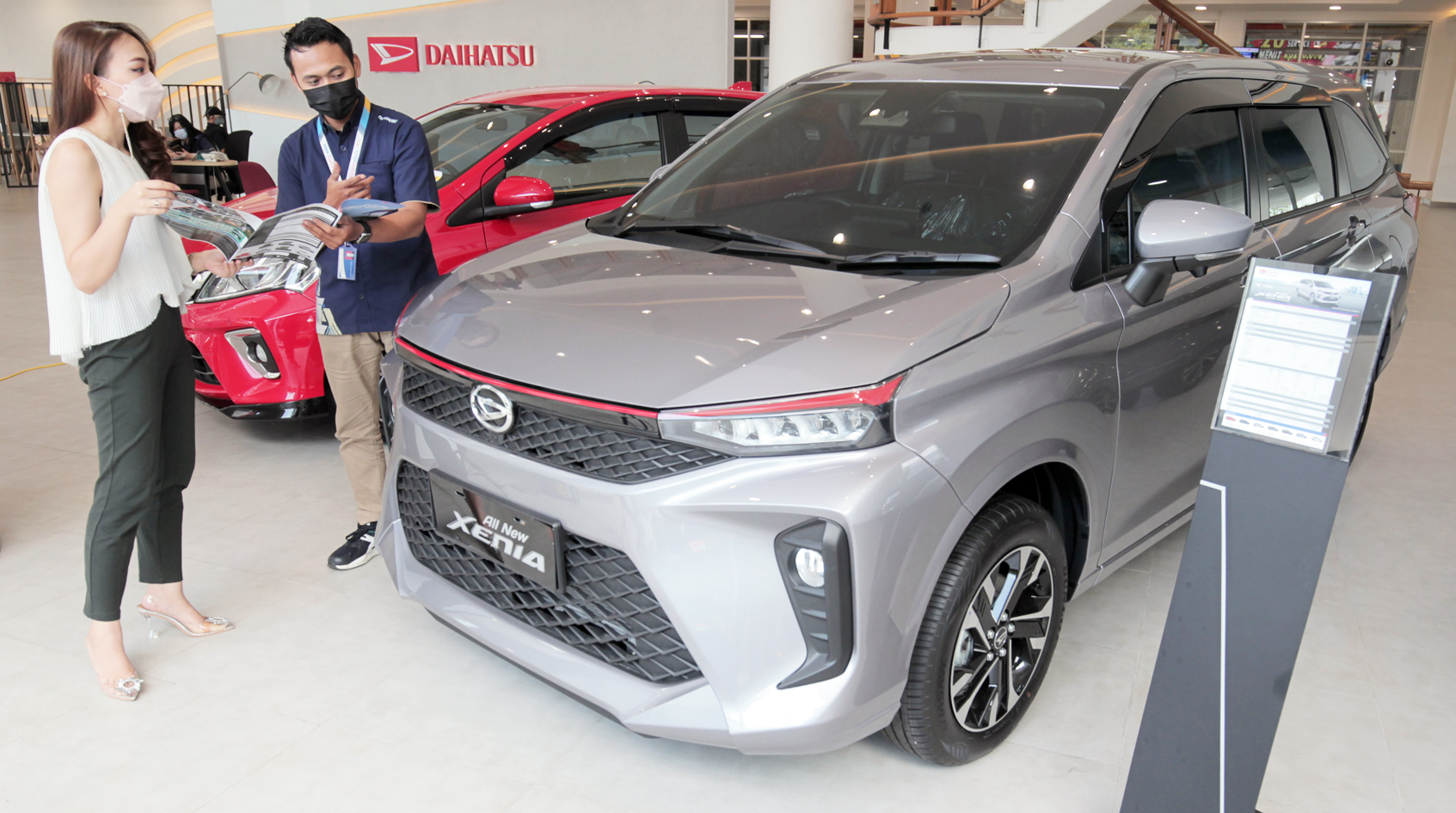 Salesperson (kanan) menjelaskan kepada konsumen fitur All New Xenia di showroom Sunter, Jakarta. 
