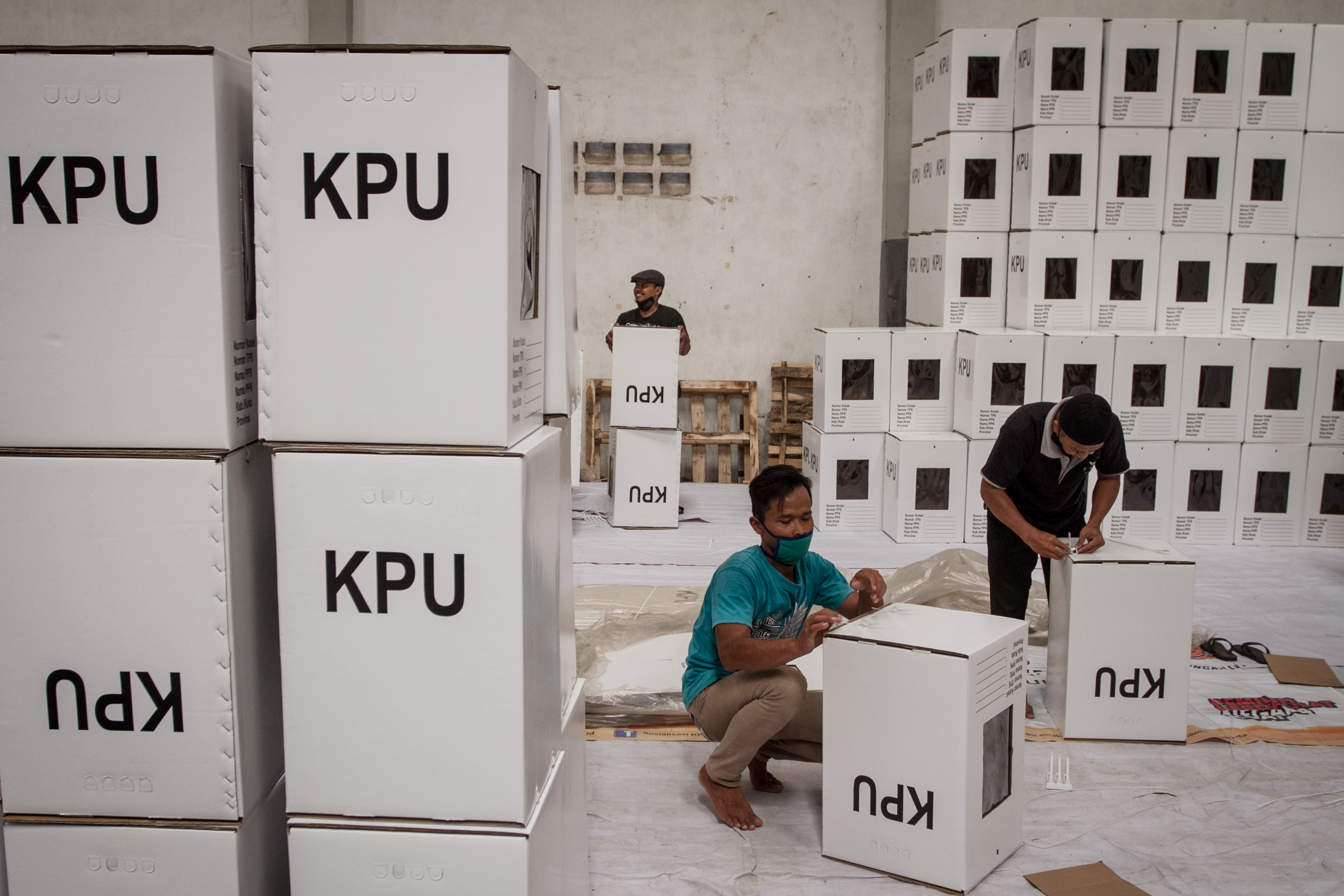 Pekerja merakit kotak suara untuk kebutuhan logistik pemilu.