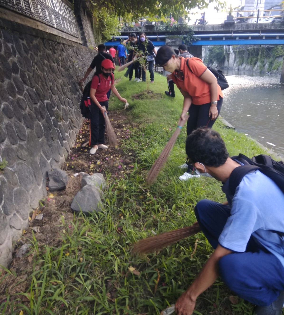 Pegawai Kelurahan Pemecutan melakukan kebersihan lingkungan dengan memungut sampah plastik dan menanam bambu