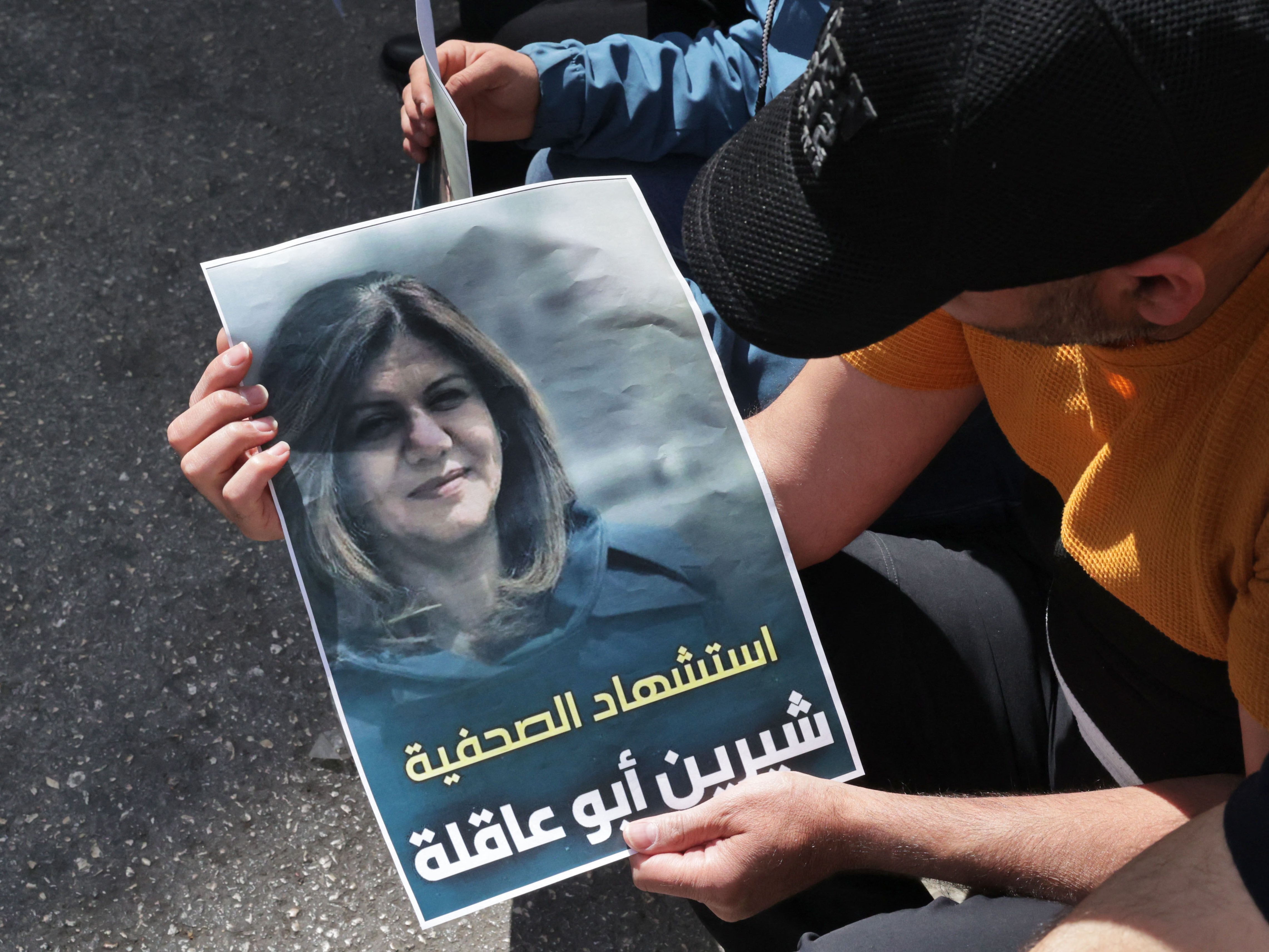 Warga Palestina memegang poster yang menampilkan jurnalis veteran Al Jazeera Shireen Abu Aqleh.