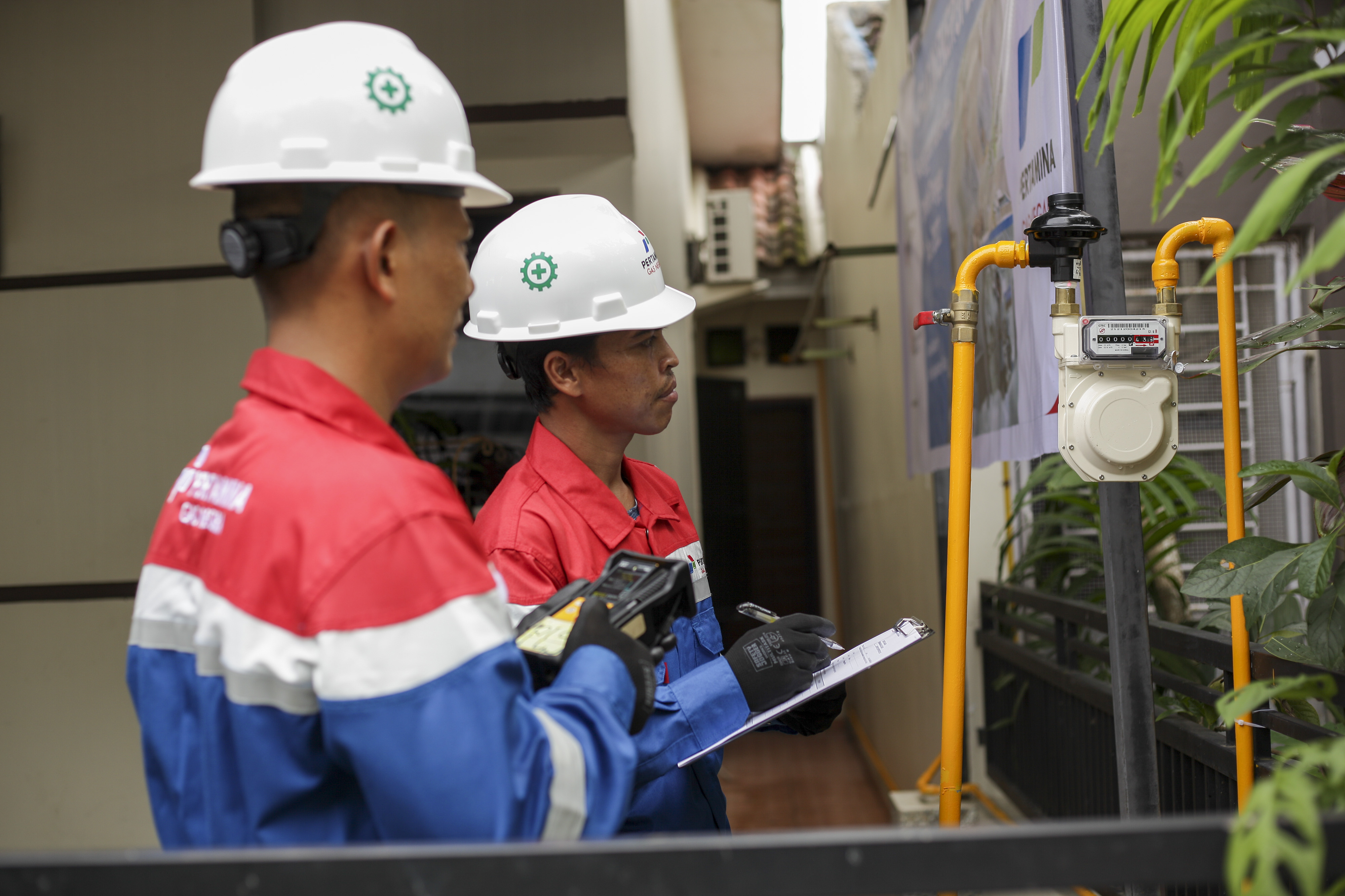 Petugas PT Perusahaan Gas Negara (Persero) Tbk (PGN) memeriksa meteran gas di salah satu rumah warga yang telah mengunakan jaringan gas bumi