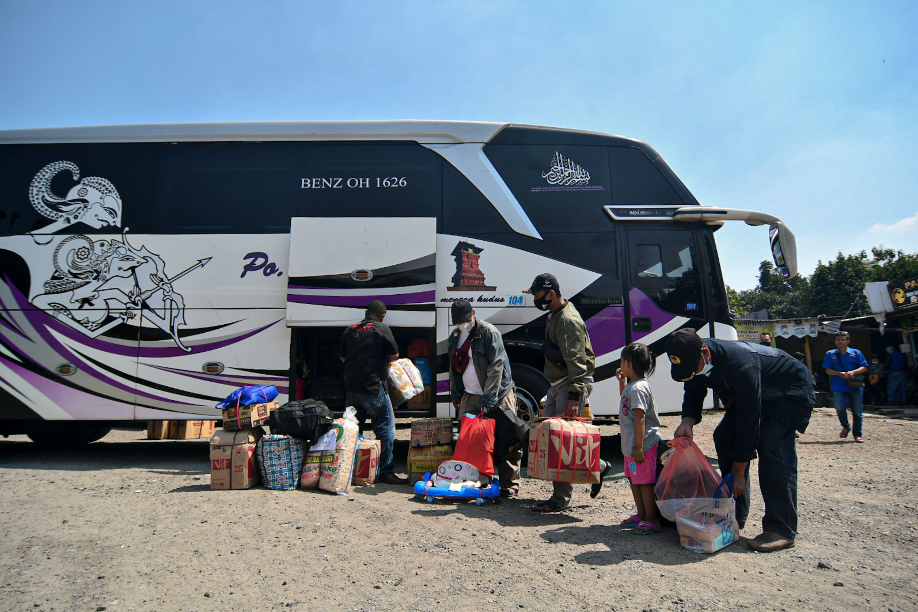 Sejumlah calon penumpang memasukan barang bawaan ke dalam bagasi bus di Terminal Bayangan Pondok Pinang, Jakarta.