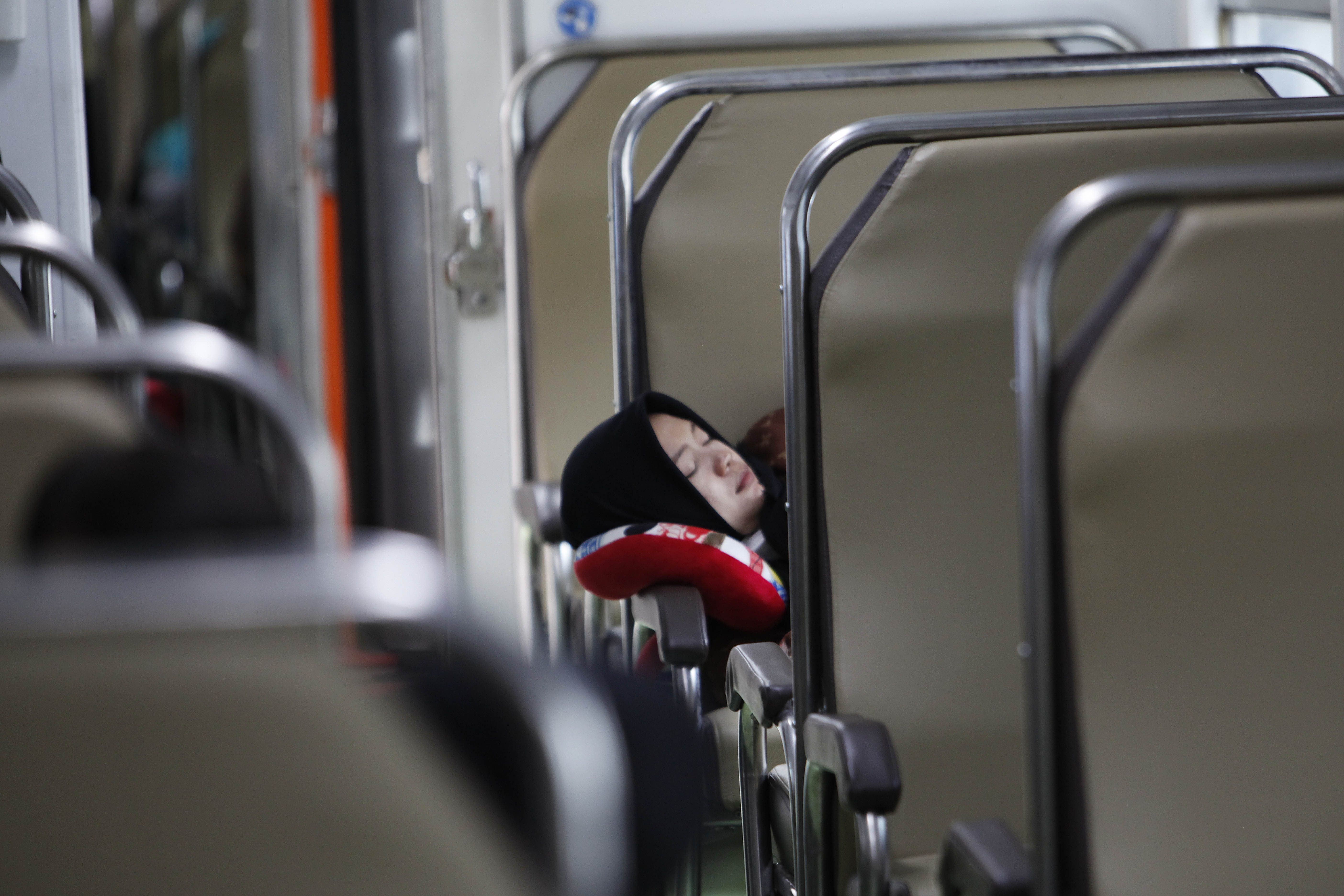 Pemudik beristirahat saat menunggu keberangkatan kereta api.