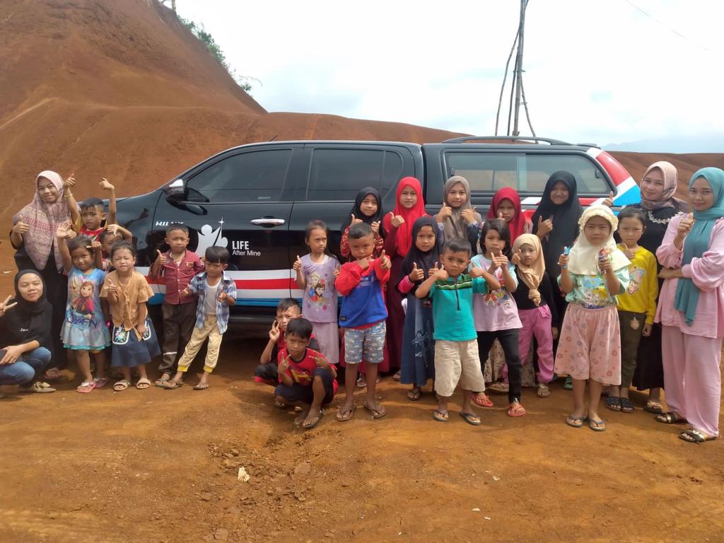 Warga dan anak-anak yang daerah terkena dampak banjir dan longsor berpose di depan kendaraan bantuan dari YLAM di Lebak, Banten. 