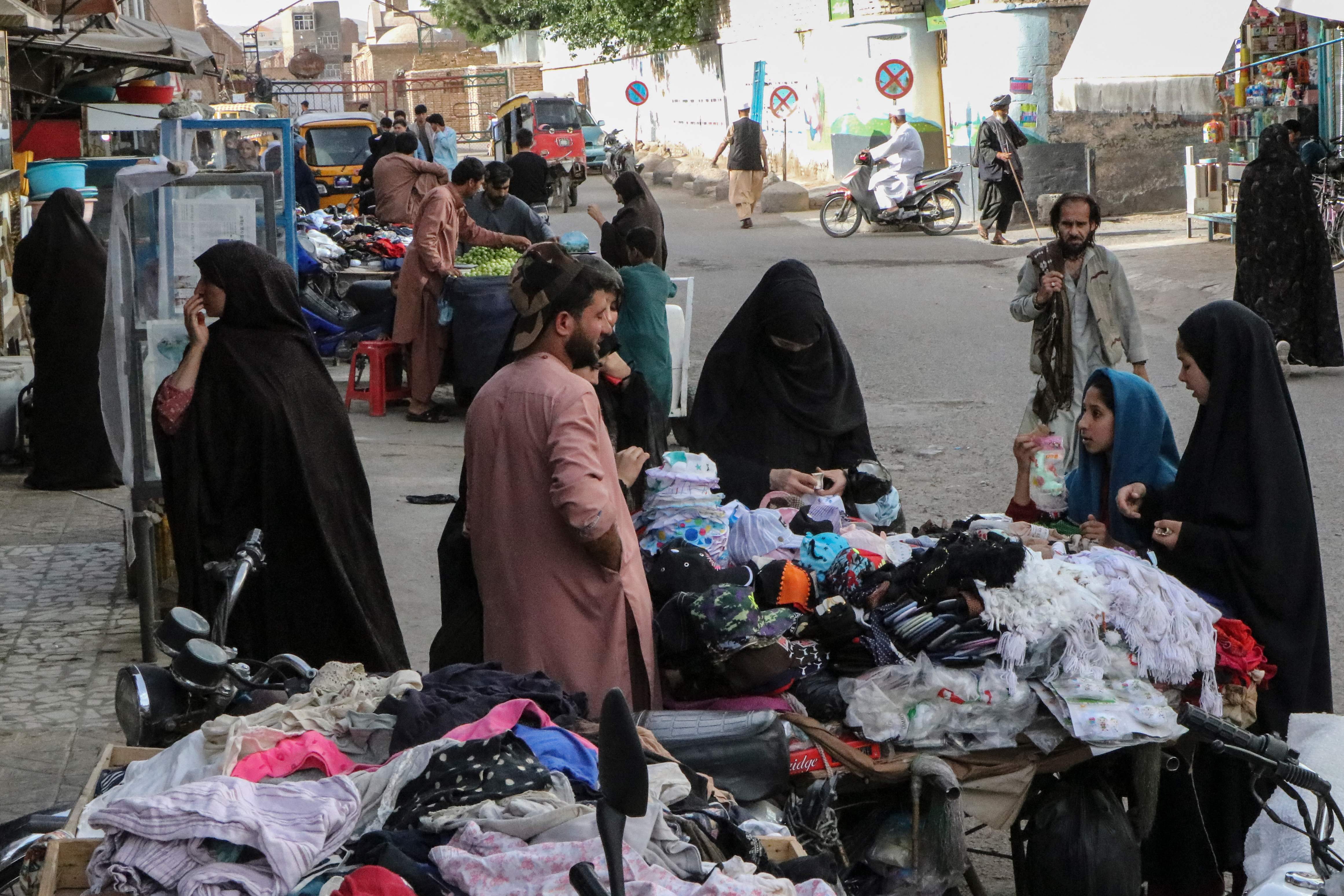 Perempuan Afghanistan dengan mengenakan burqa sedang berbelanja di sebuha pasar di Herat, Afghanistan, Sabtu (7/5). 