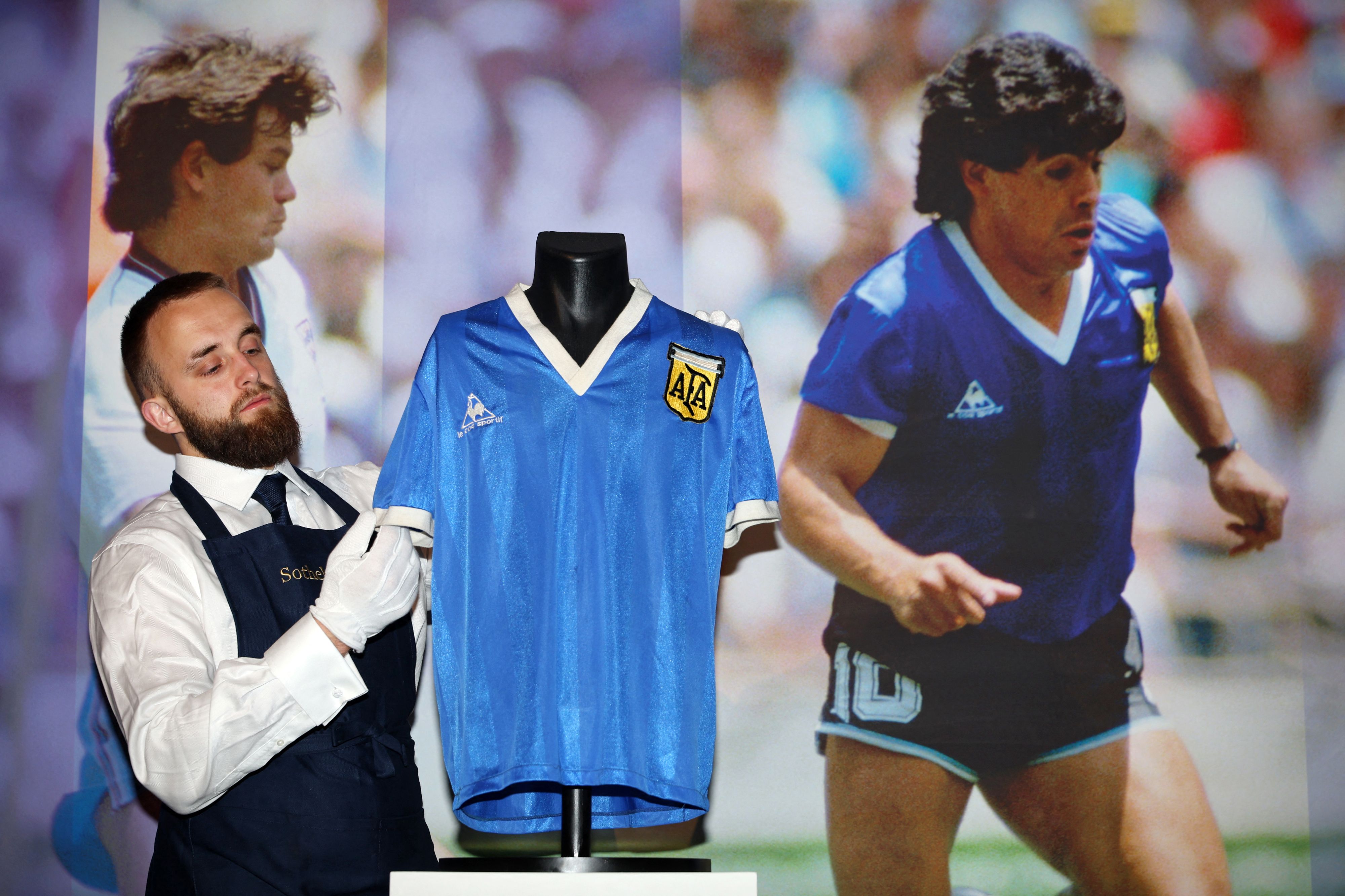 Petugas merapikan jersey yang digunakan Maradona saat mencetak gol 'Tangan Tuhan' di Piala Dunia 1986.