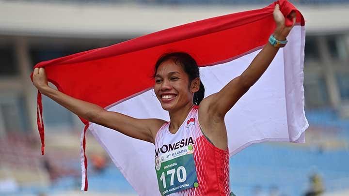 Pelari Indonesia Odekta Elvina Naibaho membentangkan bendera Merah Putih usai memenangi nomor lari maraton SEA Games