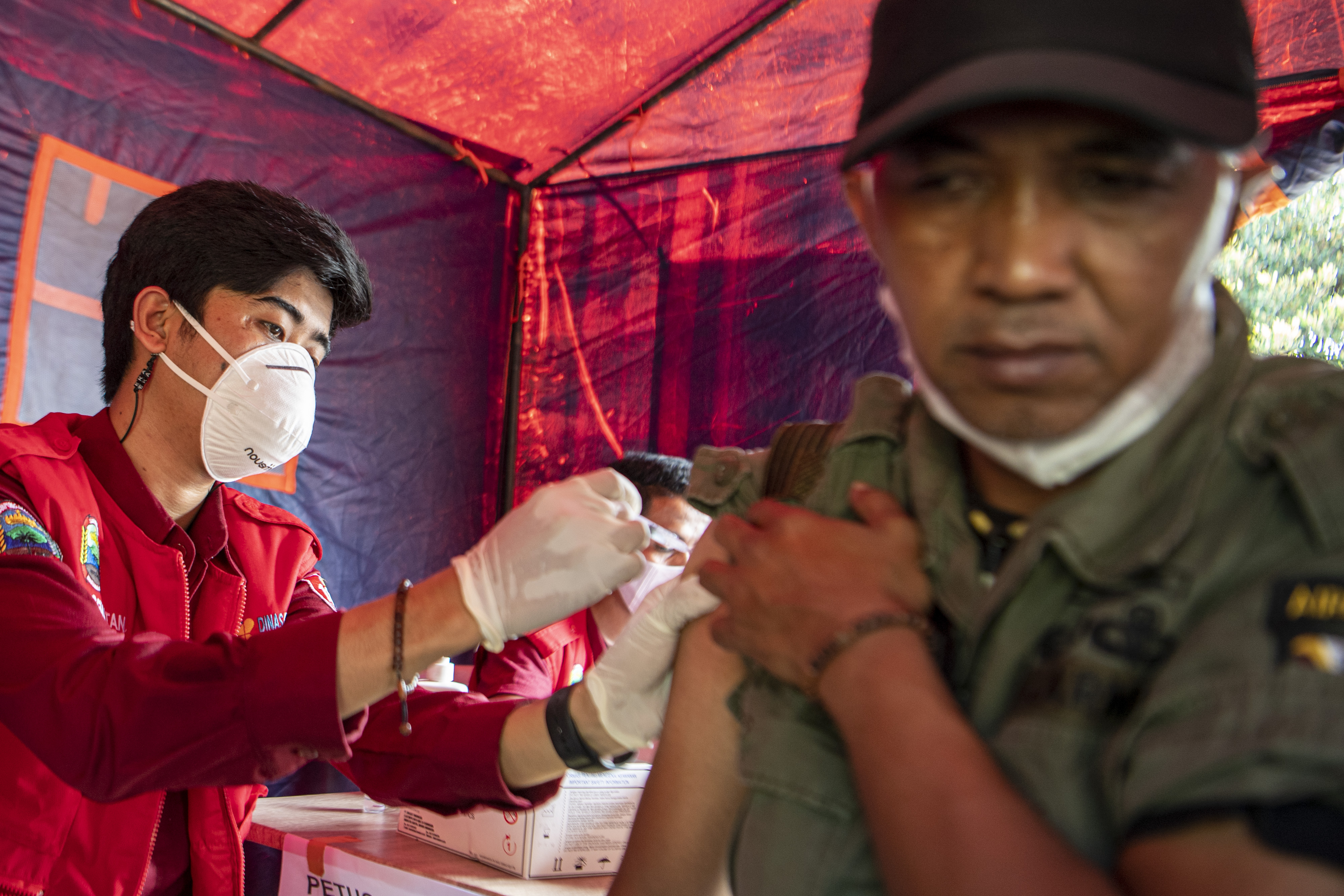 Tenaga kesehatan menyuntikkan vaksin bosster