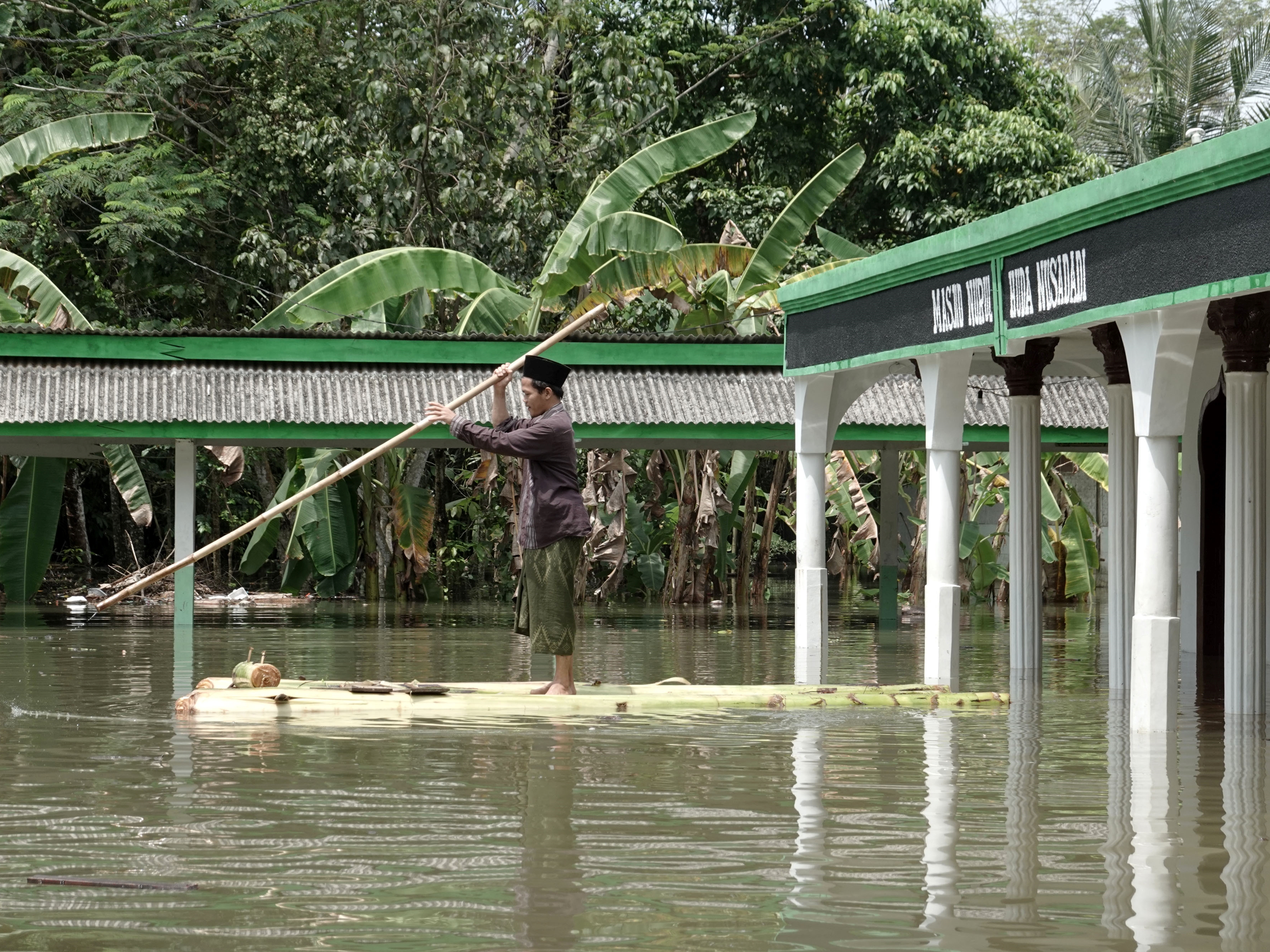 Warga menggunakan rakit darurat untuk beraktivitas di sekitar lokasi yang tergenang banjir di Desa Nusadadi, Sumpiuh, Banyumas, Jateng.