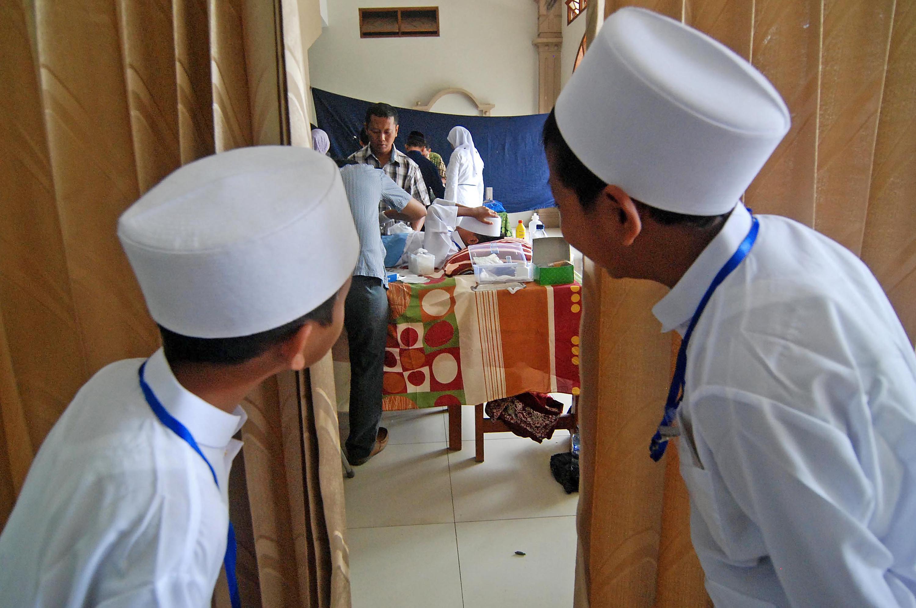 Dua anak mengintip acara Sunatan Massal Anak Soleh di Ungaran, Kabupaten Semarang, Jawa Tengah.