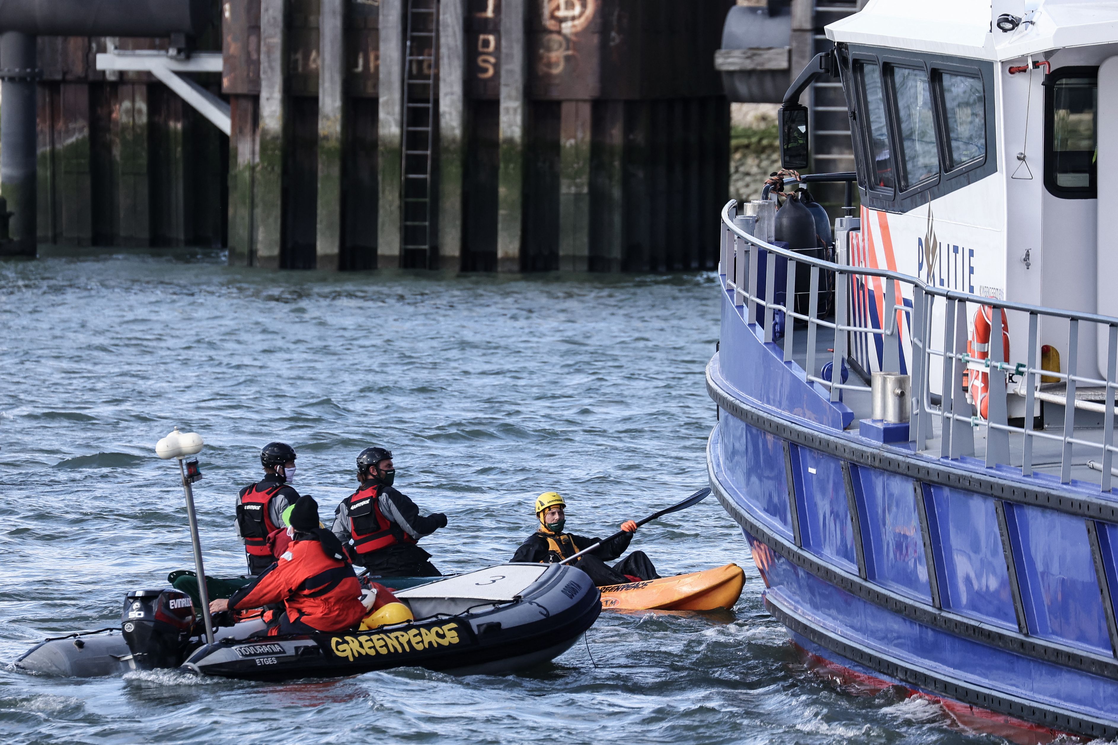 Aktivis Greenpeace berusaha menghentikan kapal polisi saat anjuk rasa desak UE setop penggunaan bahan bakar fosil di Rotterdam, Belanda. 