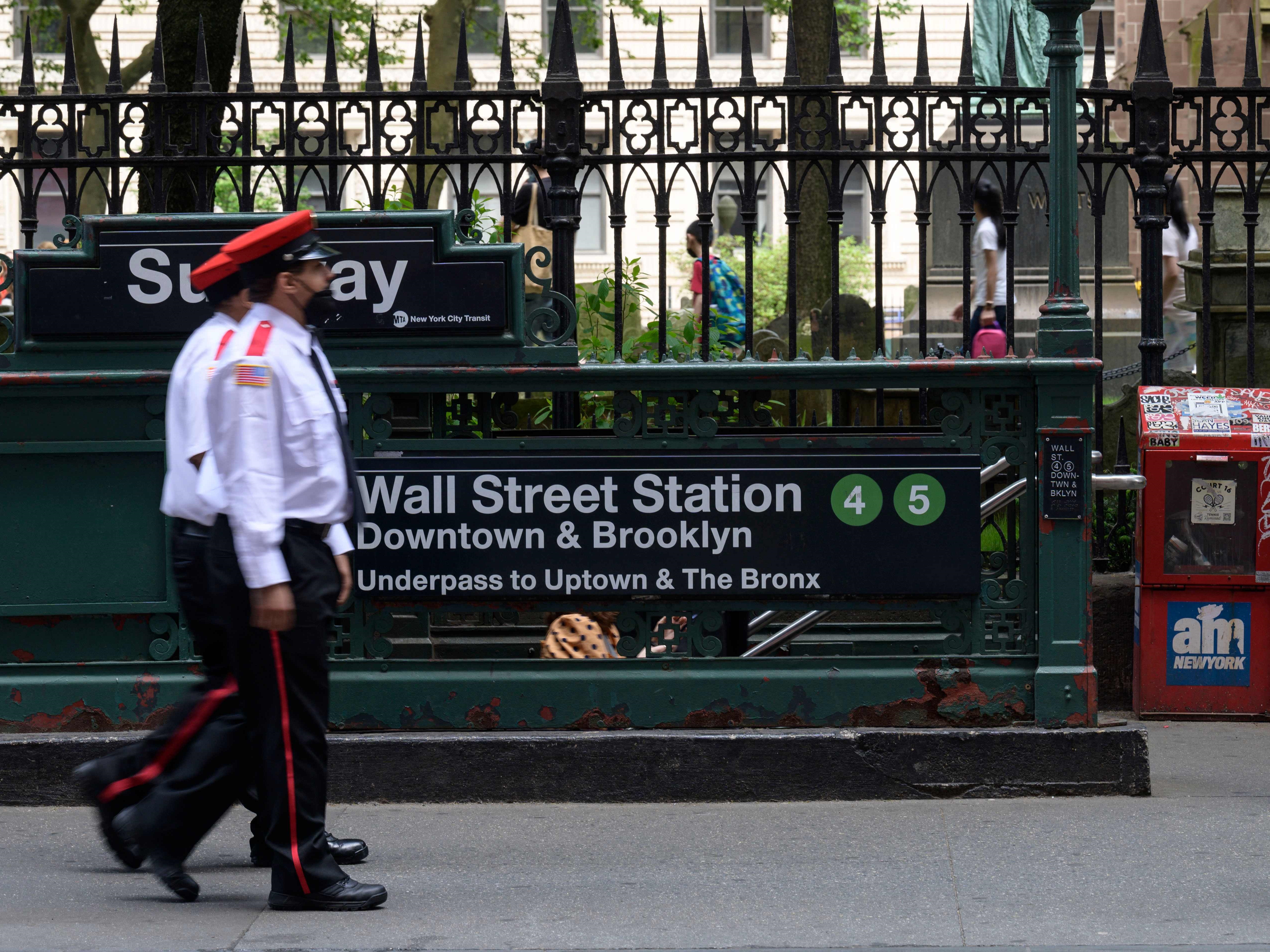 Penjaga keamanan berjalan melewati stasiun kereta bawah tanah Wall Street dekat New York Stock Exchange (NYSE) pada 27 Mei 2022.