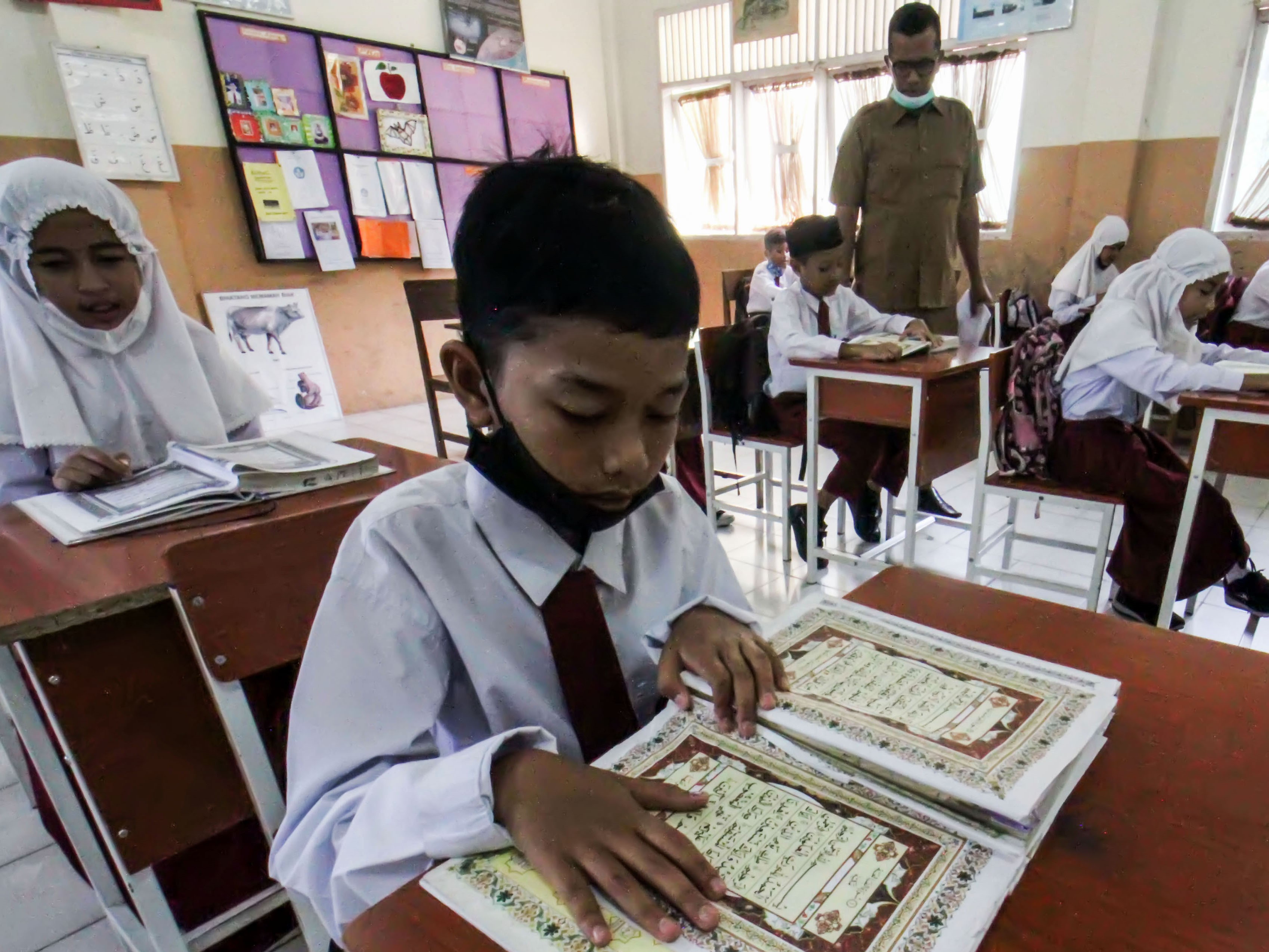 Siswa SDN 1 Lhok Seumawe membaca Al-Qur'an pada hari pertama sekolah di Ramadan 1443 Hijriah di Aceh, Senin (11/4).