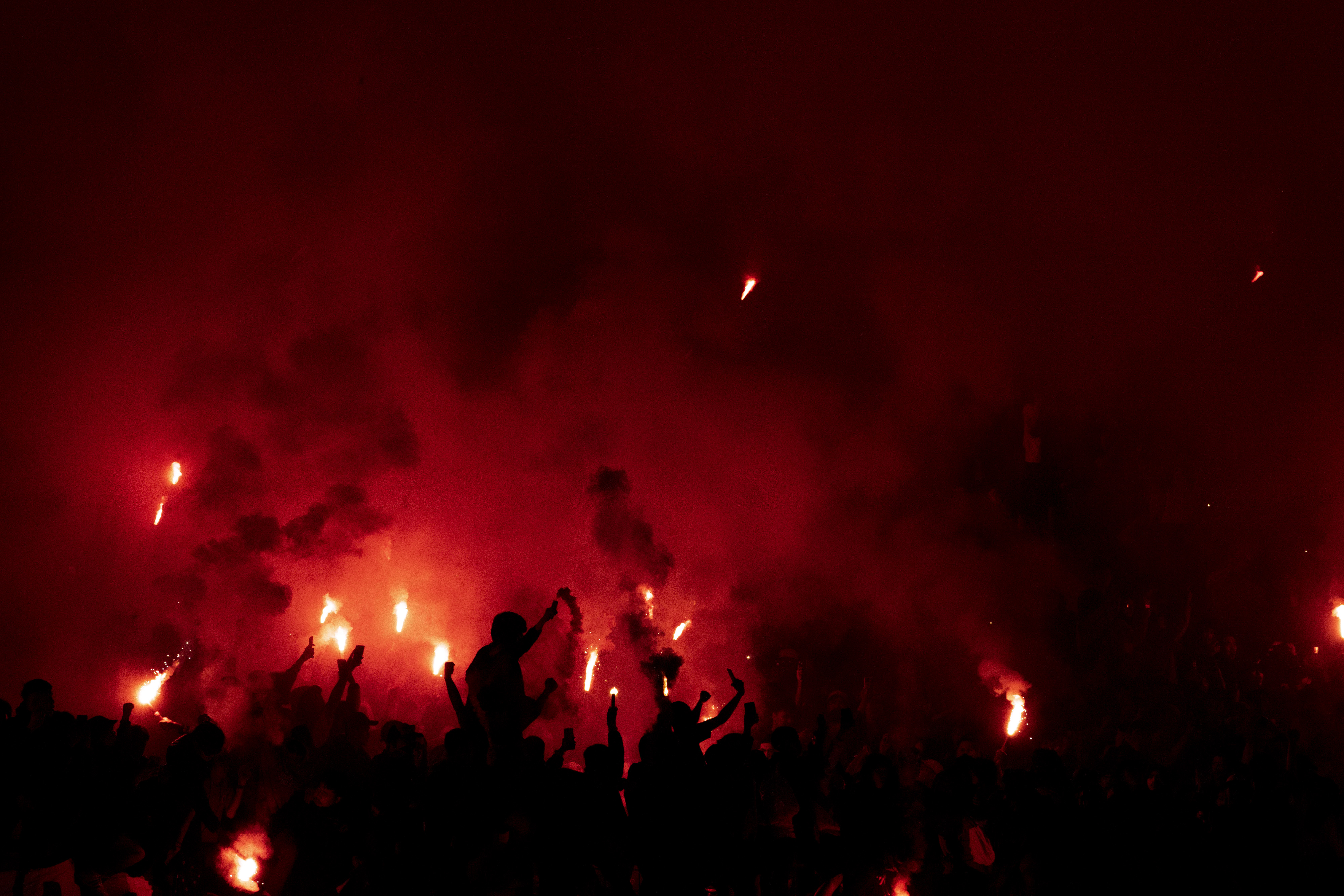 Suporter Persib Bandung menyalakan flare usai pertandingan Persebaya Surabaya melawan Persib Bandung