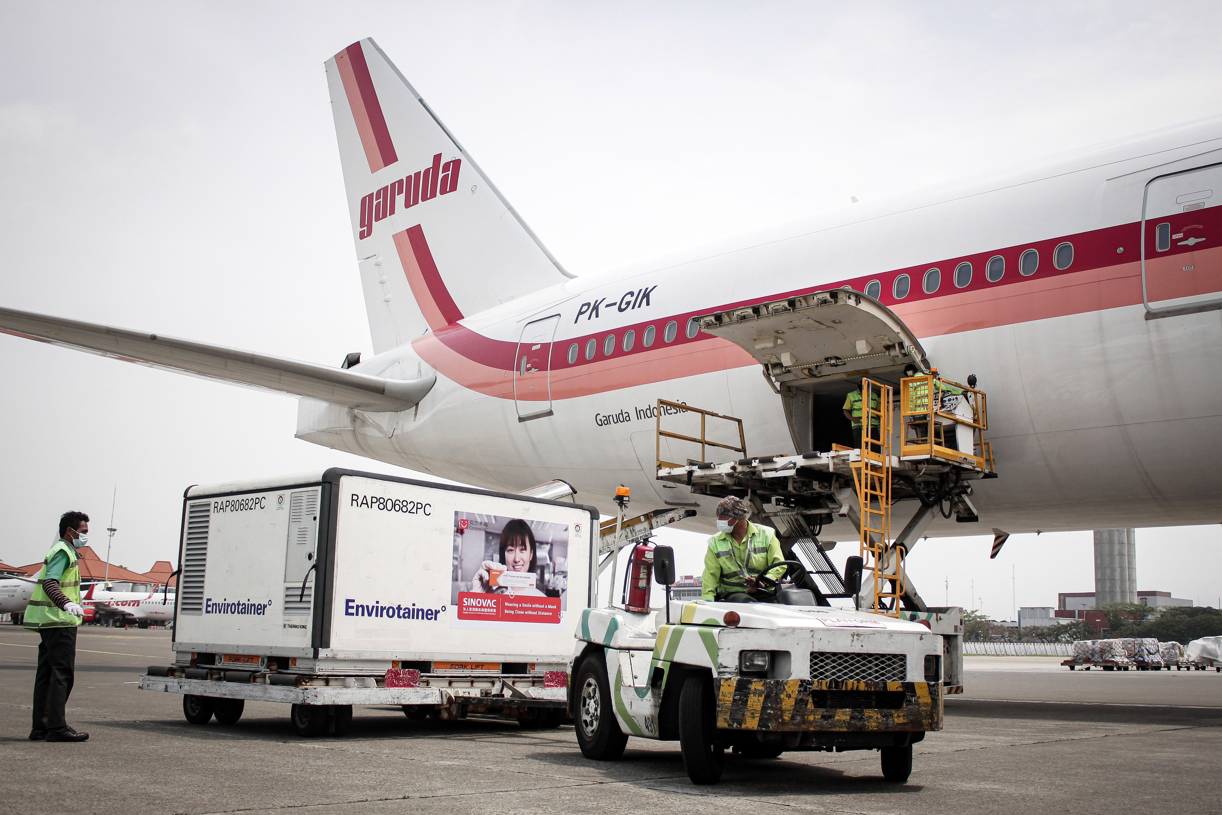 Petugas kargo membawa envirotainer berisi vaksin covid-19.