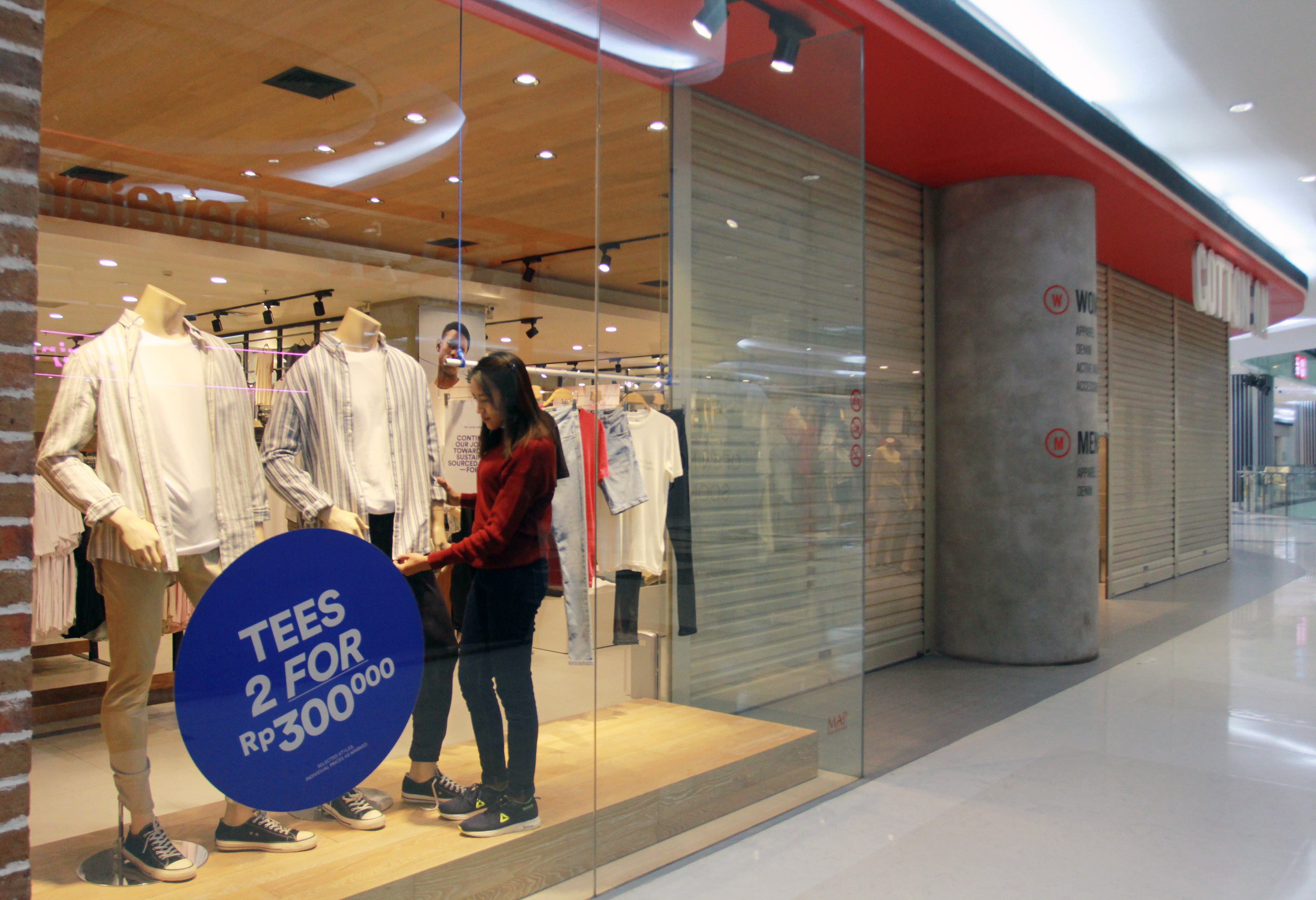 Pekerja membersihkan dan membereskan barang dagang disebuah tenant yang ada di pusat perbelanjaan Lippo Mall Puri, Jakarta.