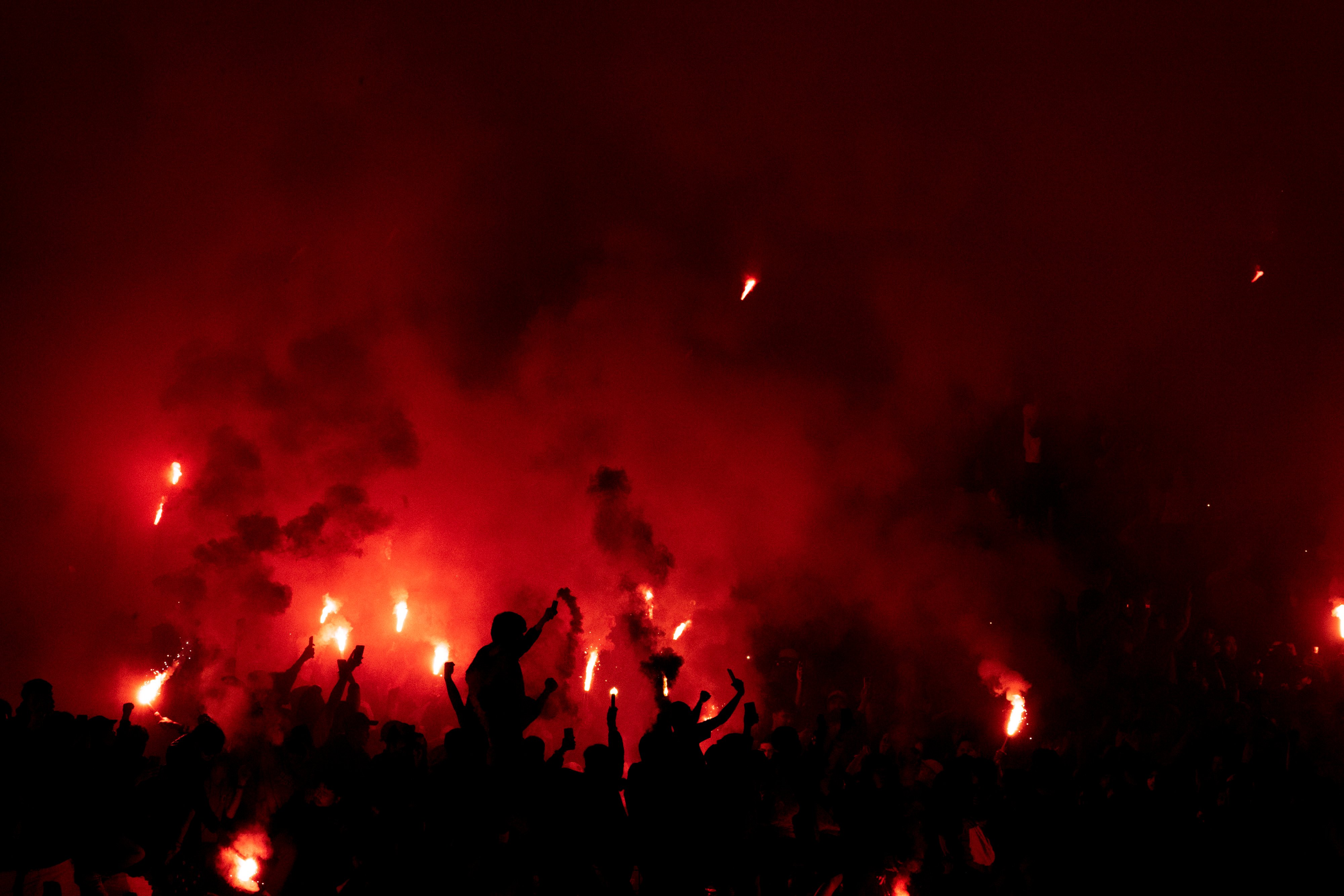 Suporter Persib Bandung menyalakan flare usai pertandingan Persebaya Surabaya melawan Persib Bandung