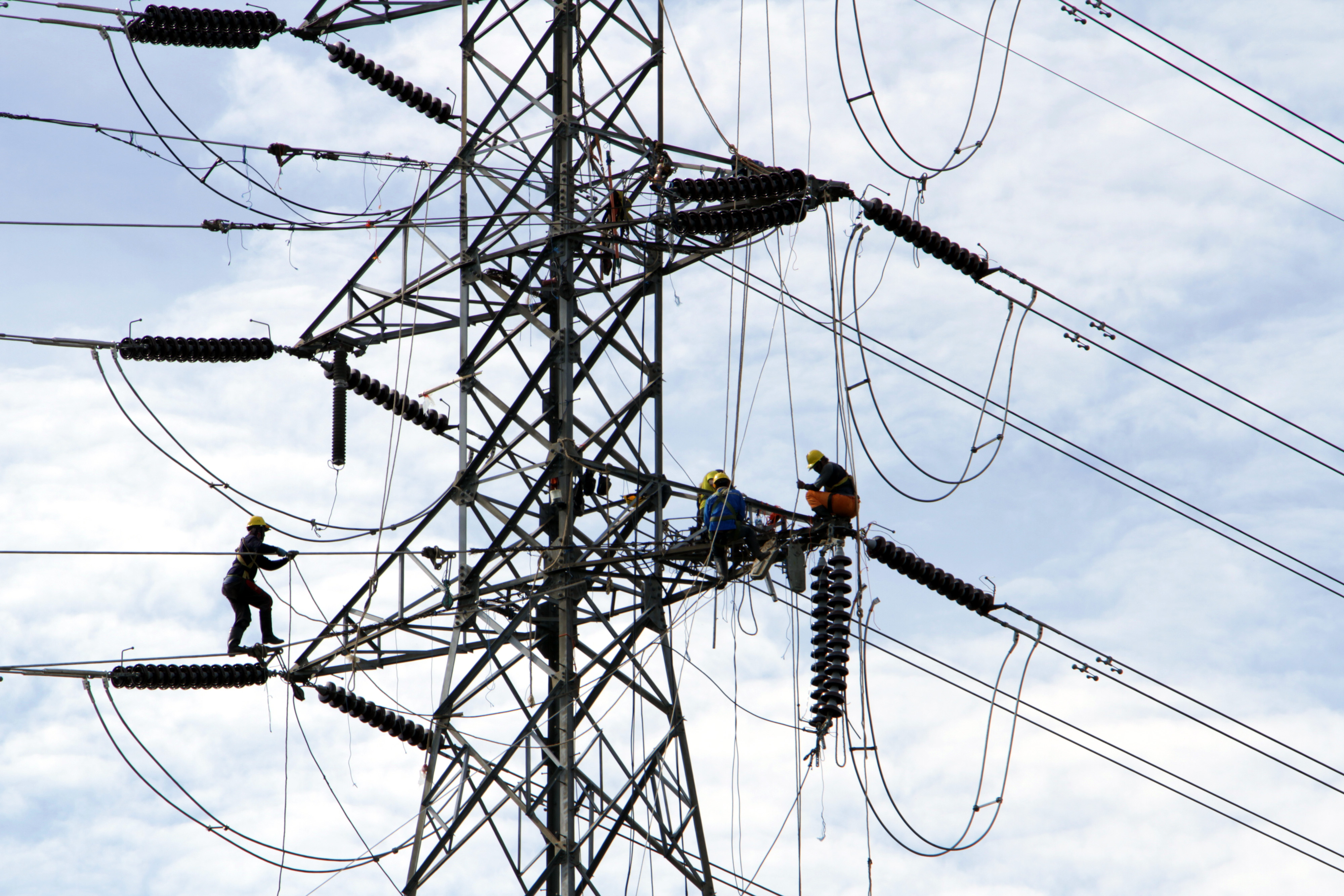 Pekerja memasang jaringan transmisi tenaga listrik di Kabupaten Gowa, Sulawesi Selatan.