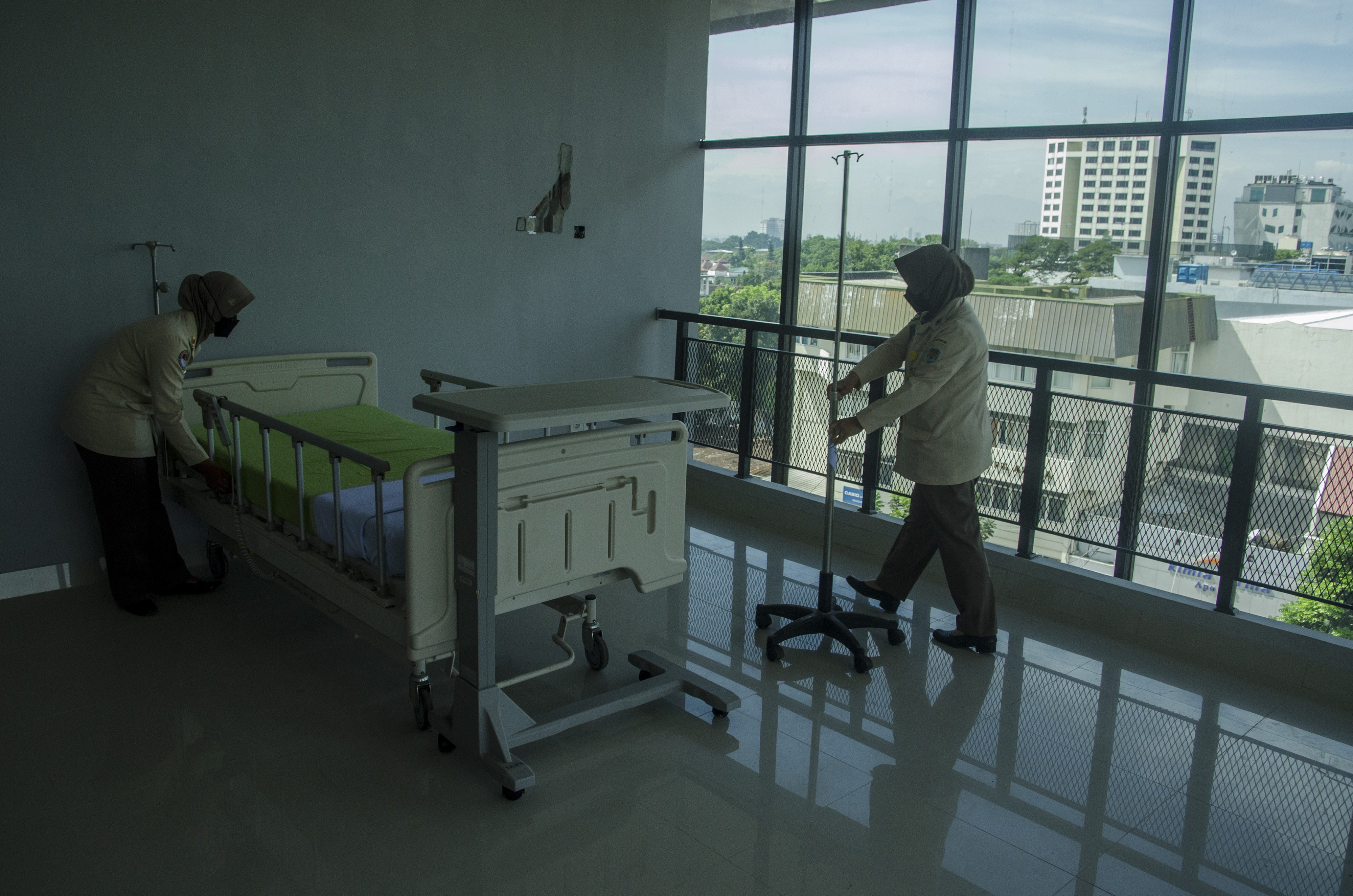 Tenaga kesehatan TNI merapikan kasur ruangan rawat inap rumah sakit.