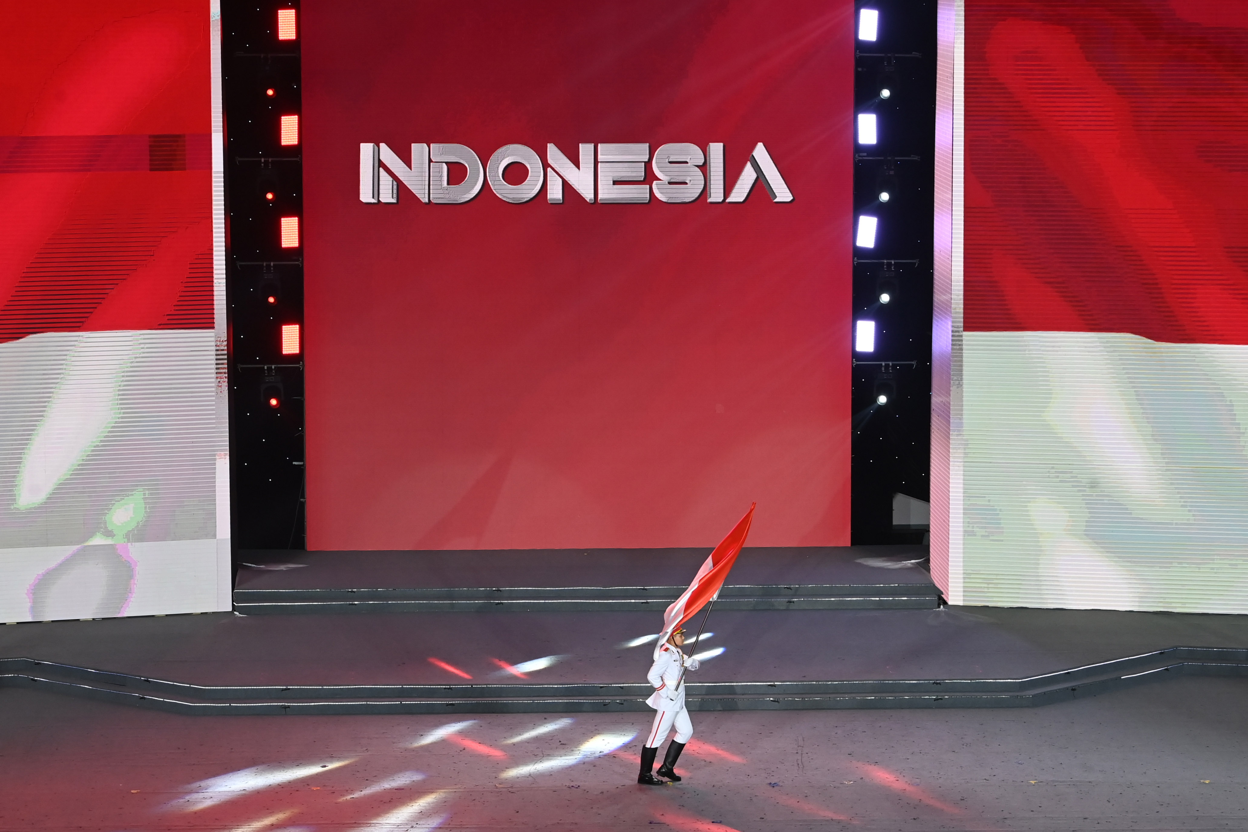 Petugas membawa bendera Indonesia di acara pesta olahraga internasional.