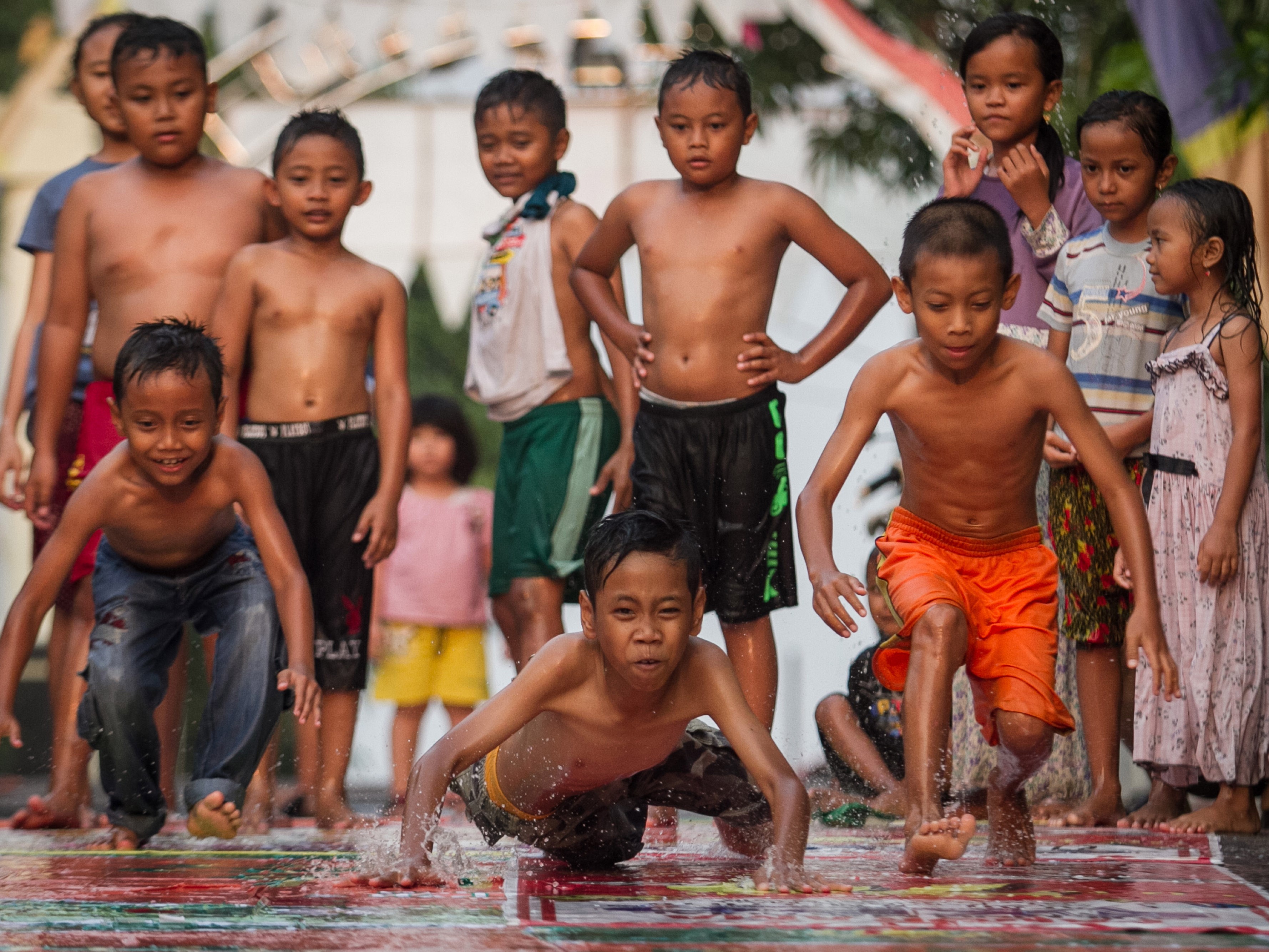 Anak-anak bermain perosotan di kampung Kadipiro, Solo, Jawa Tengah, Senin (2/7). 