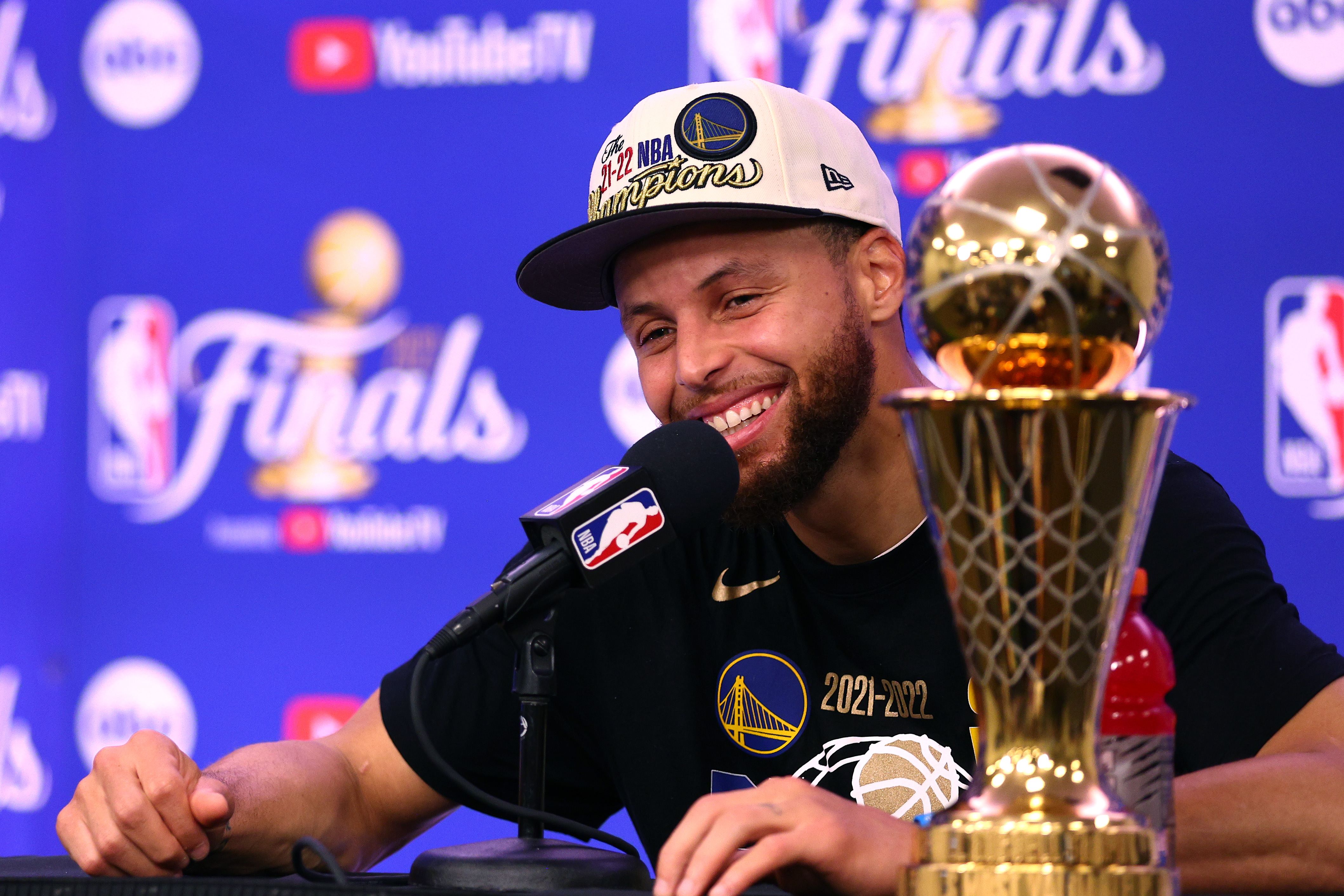 Pebasket Golden State Warriors Stephen Curry dan Trofi Bill Russell yang diberikan kepada MVP Final NBA.
