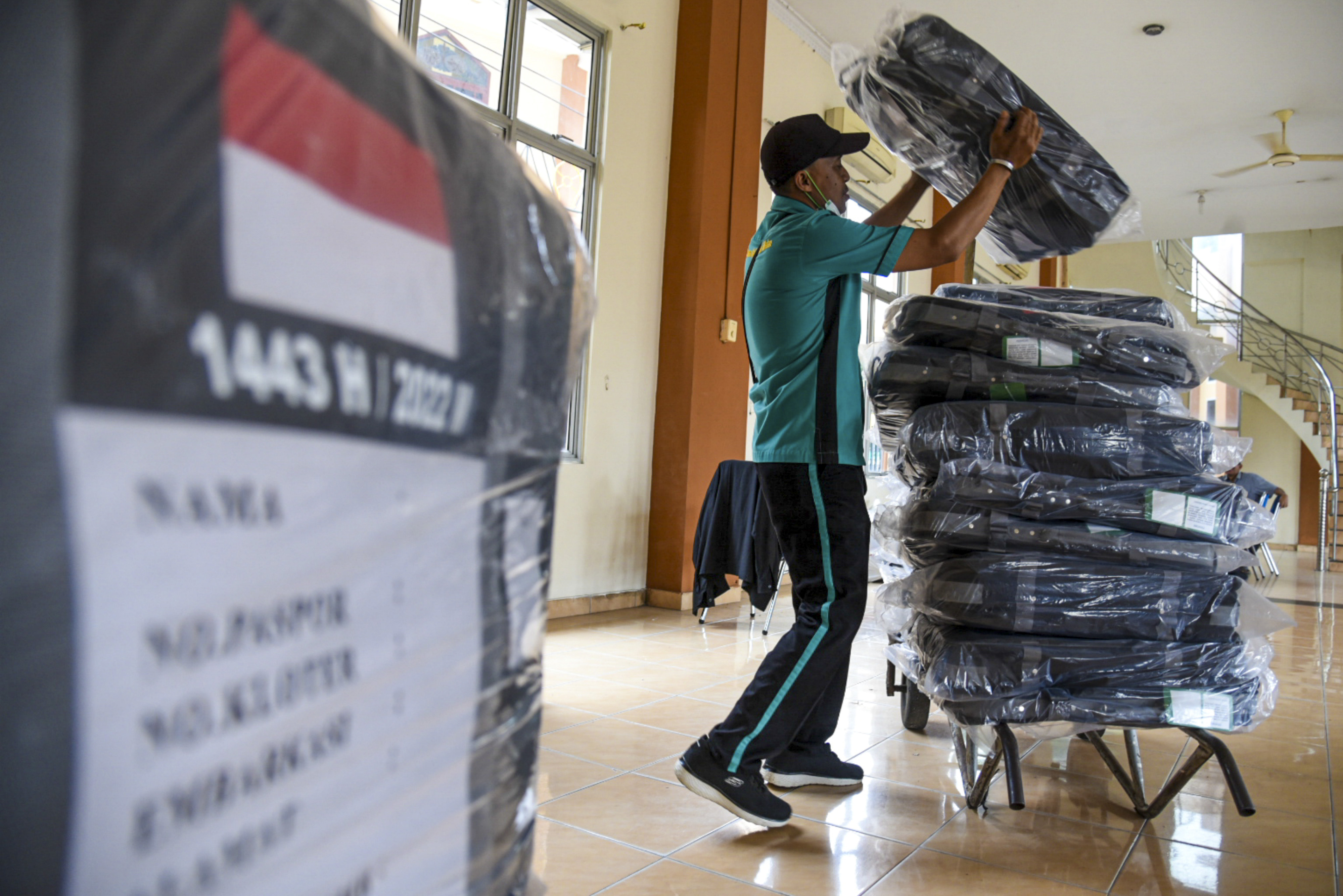 Petugas menyusun koper jemaah calon haji di Asrama Haji Embarkasi Kota Medan, Sumatera Utara, Rabu (8/6/2022). 