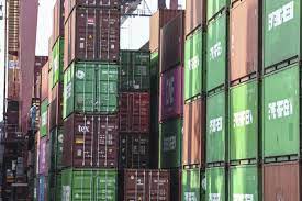 Pekerja berjalan di samping peti kemas di Pelabuhan Tanjung Priok, Jakarta. 