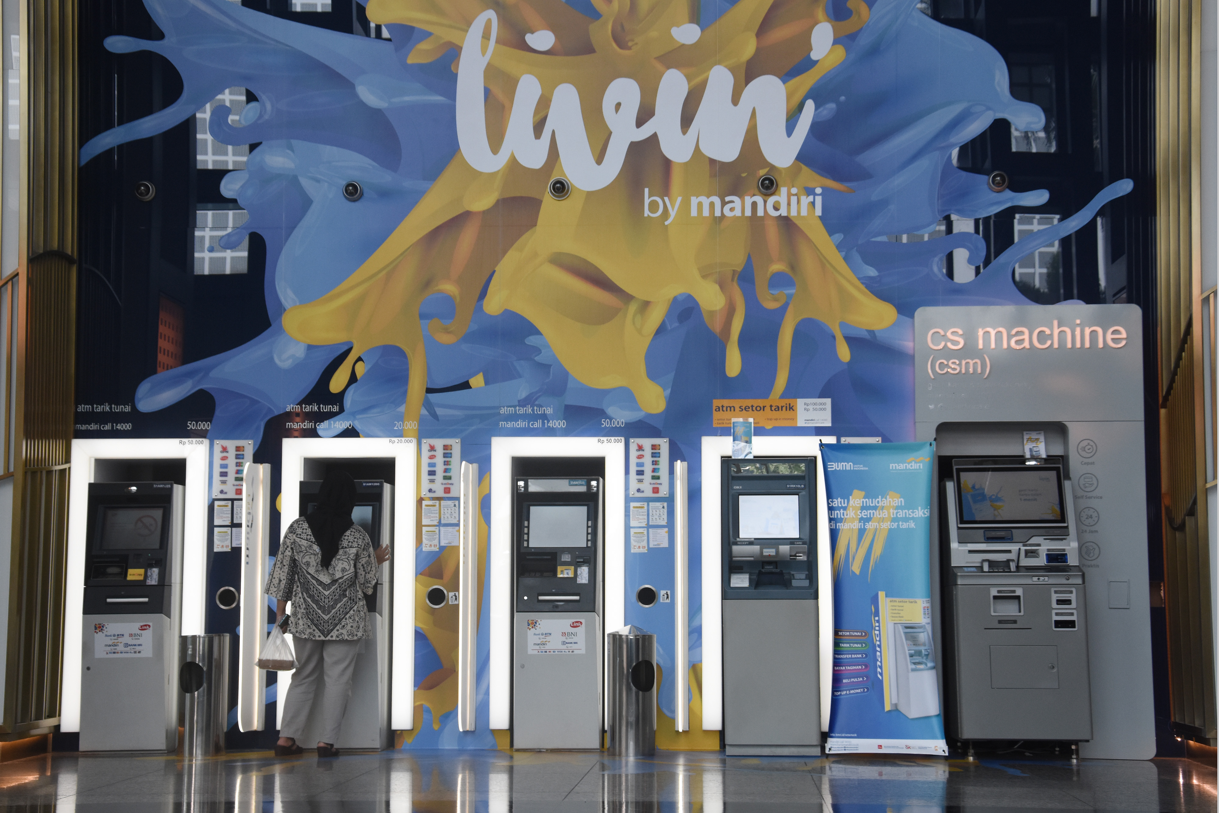 Nasabah bertransaksi melalui mesin ATM Bank Mandiri di Jakarta.