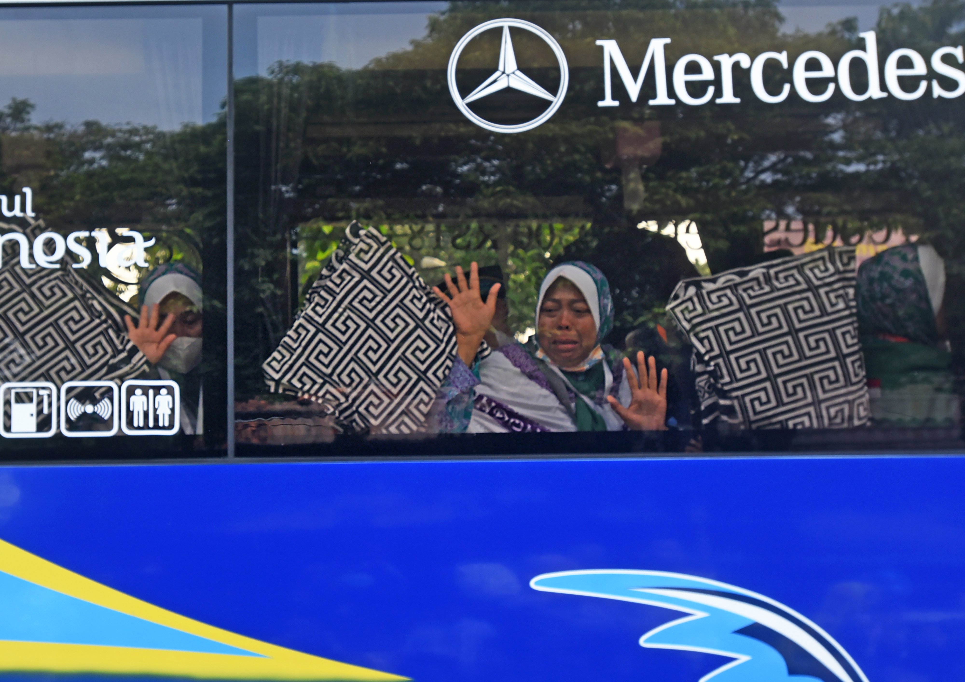 Sejumlah calon haji melambaikan tangan kepada keluarganya jelang keberangkatan.