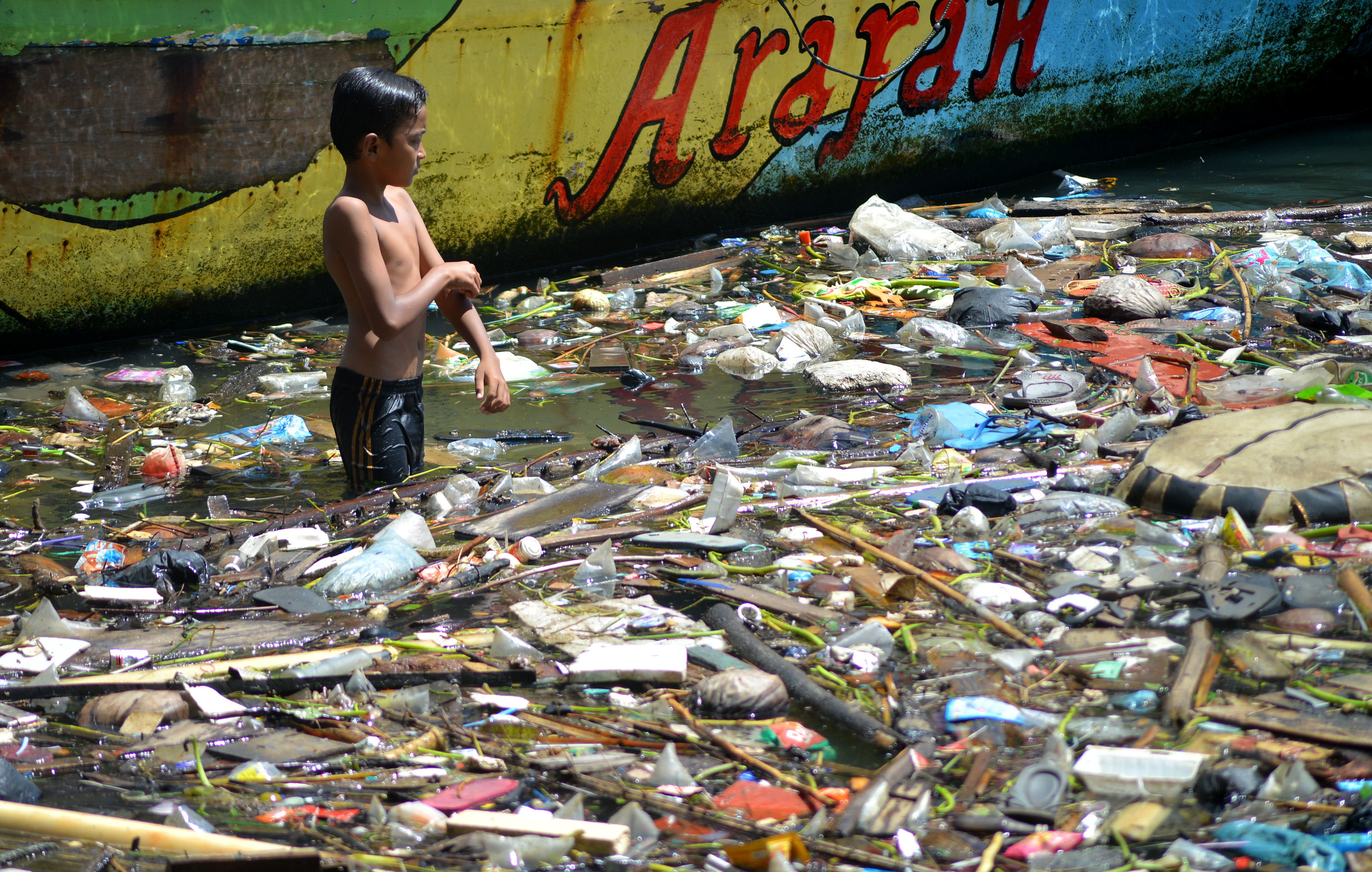 Anak-anak bermain di antara sampah di Sungai Batang Arau, Padang, Sumatra Barat.