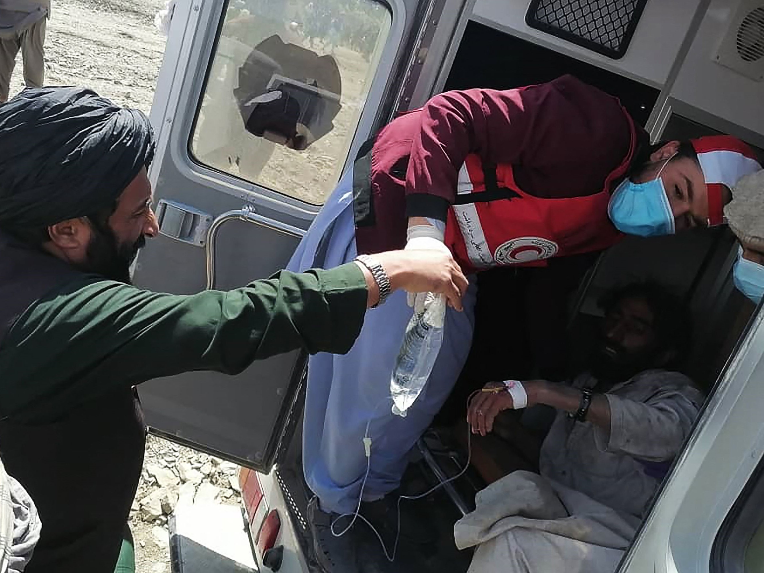 Anggota Masyarakat Bulan Sabit Merah Afghanistan memberikan perawatan medis kepada seorang korban setelah gempa bumi di Gayan, Paktika.
