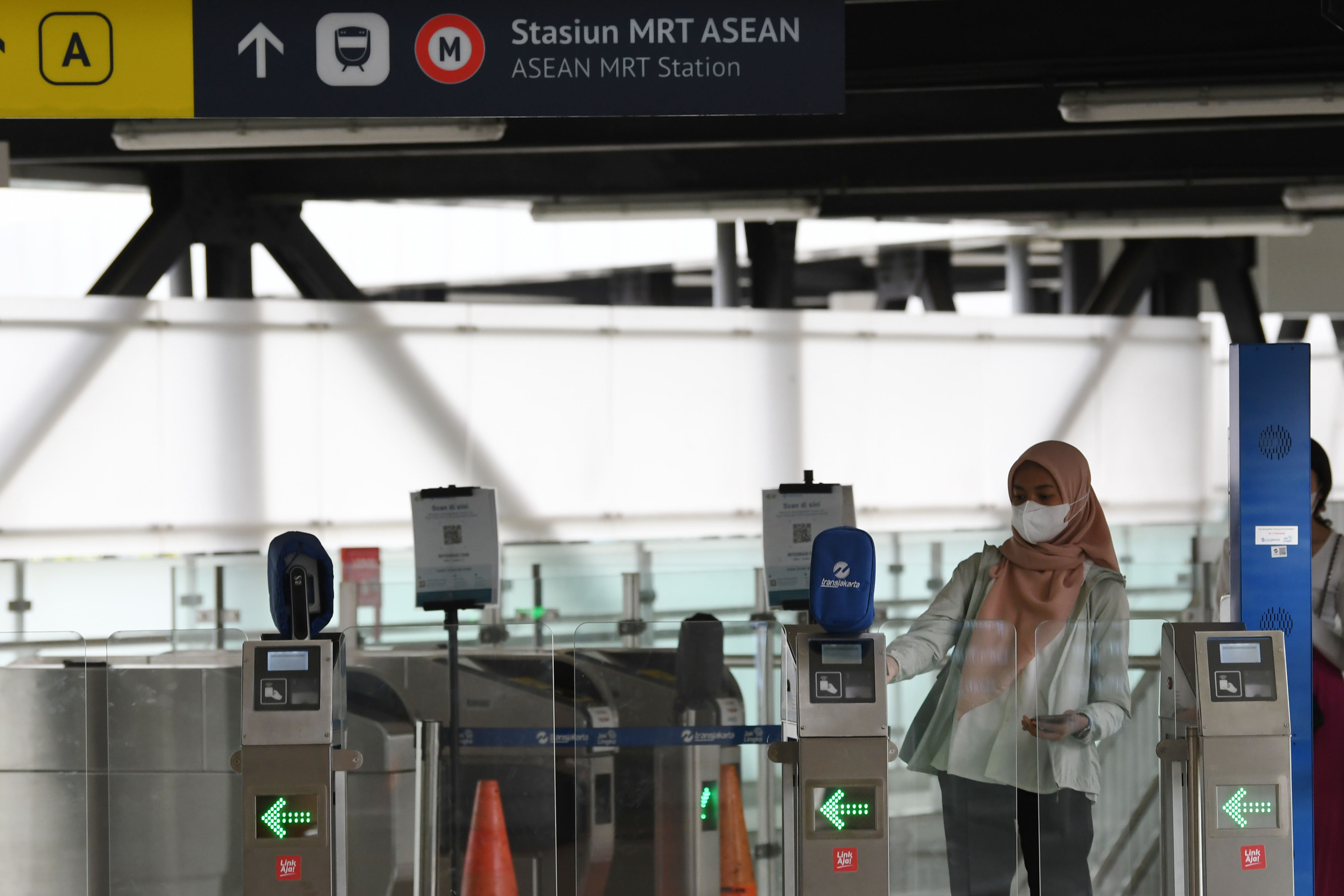 Warga menempelkan kartu pembayaran non tunai sebelum memasuki Halte Bus TransJakarta CSW