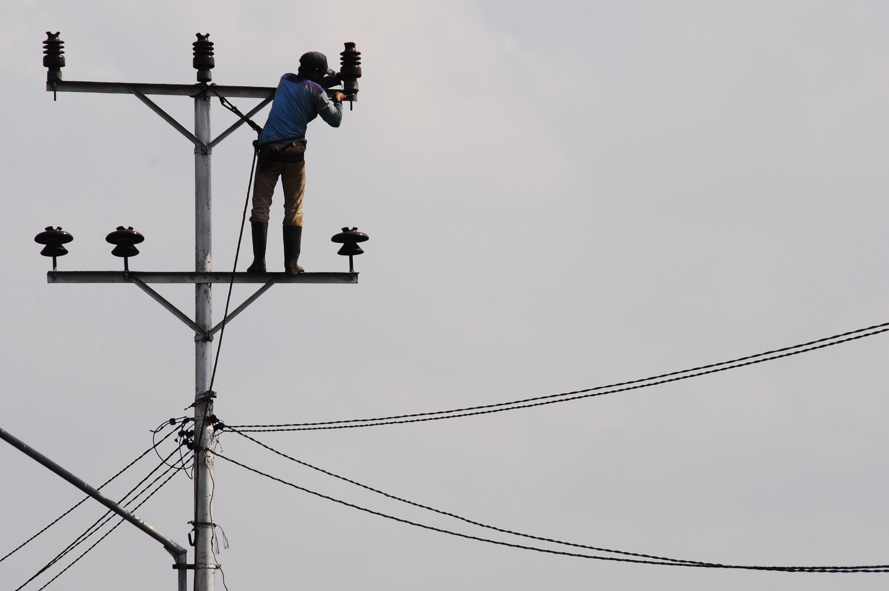 Seorang pekerja sedang memperbaiki instalasi jaringan listrik di Jalan Ahmad Yani Pontianak, Kalbar, beberapa waktu lalu.