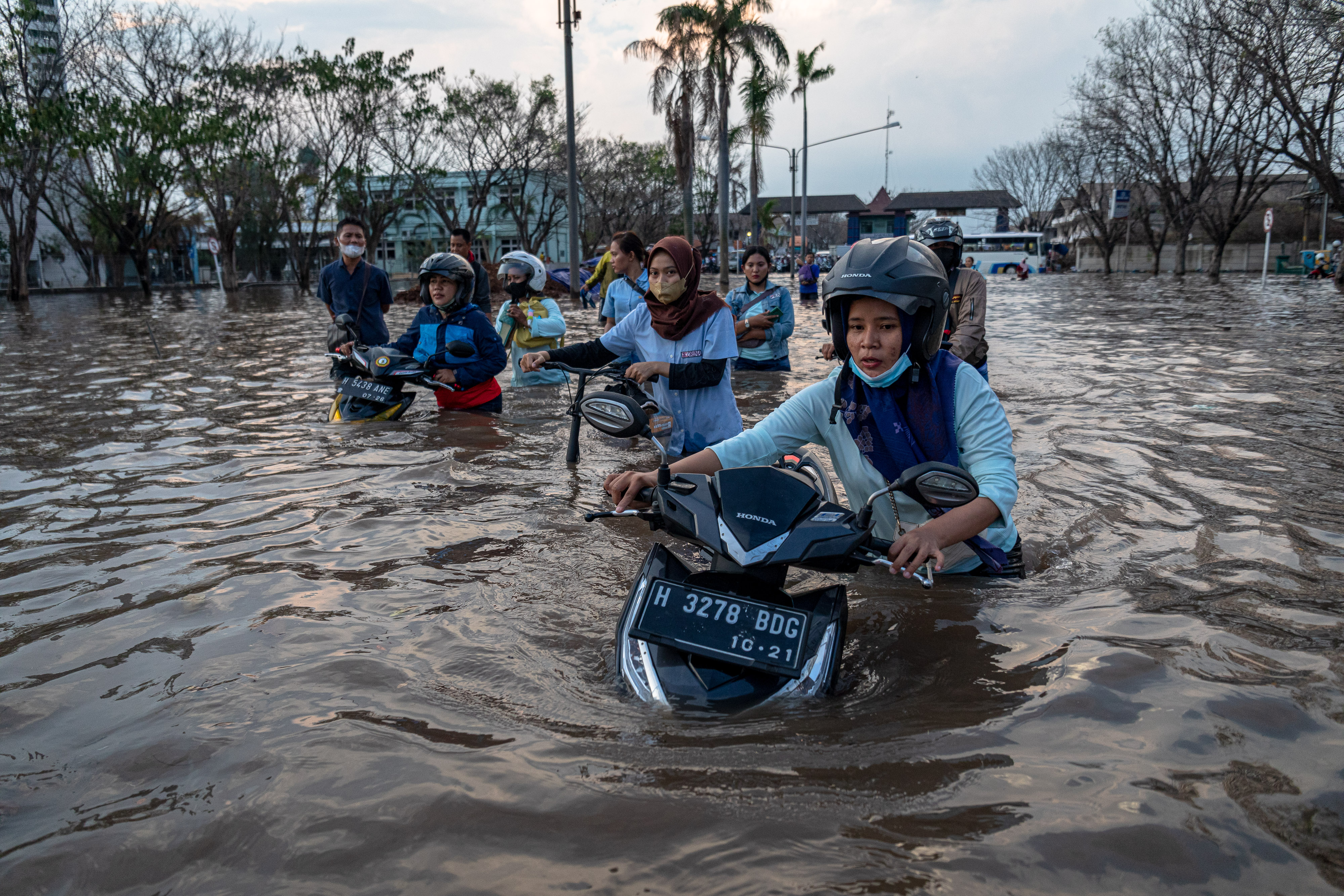 Sejumlah pekerja perempuan menembus banjir rob di kawasan Pelabuhan Tanjung Emas Semarang, Jawa Tengah, Senin (20/6).